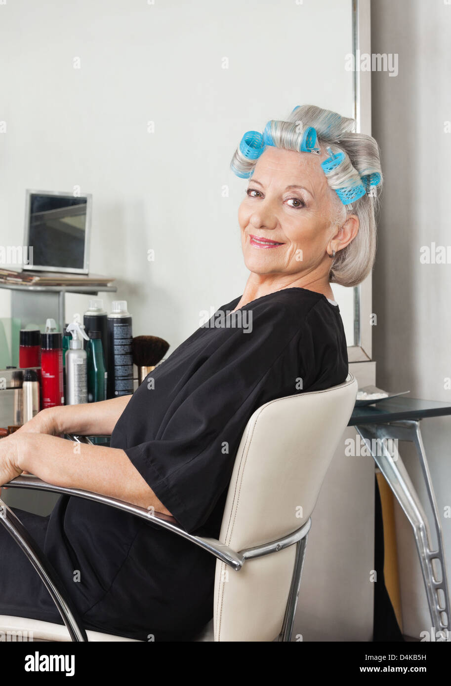 Woman With Hair Curlers Sitting On Chair At Salon Stock Photo - Alamy