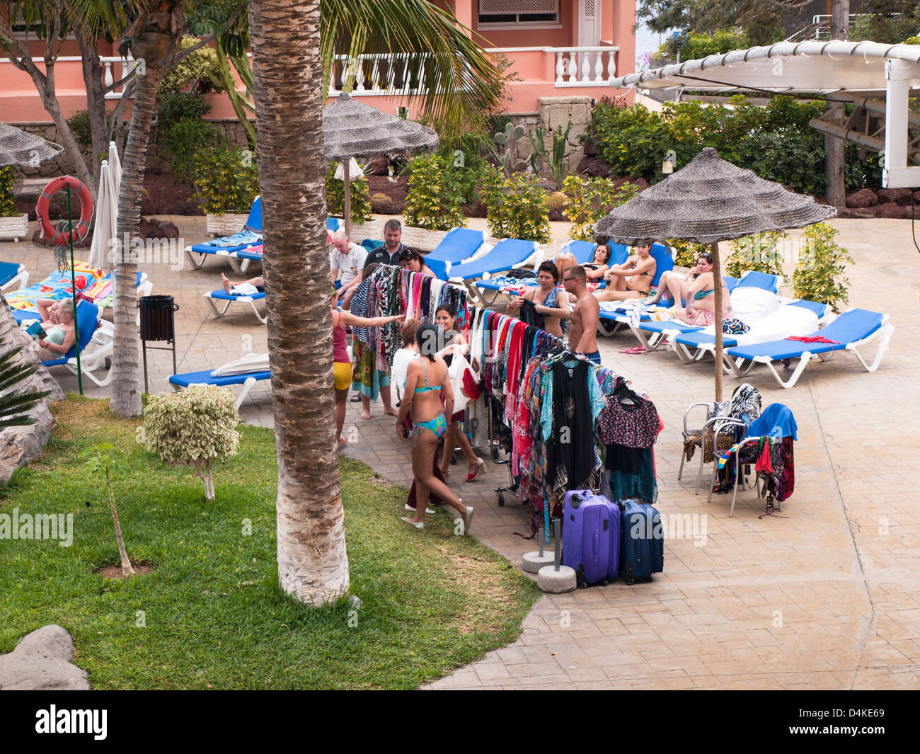 Ambulant vendor of beach clothing on the side of a hotel pool in Tenerife Canary Islands Spain Stock Photo