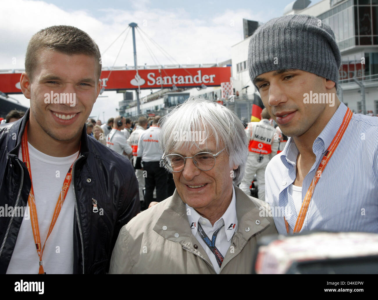 F1 boss Bernie Ecclestone (C), German boxer Felix Sturm (R), WBA Middleweight World Champion, and German soccer player Lukas Podolski (L) meet in the grid prior to the start of the Grand Prix of Germany at the Nuerburgring race track in Nuerburg, Germany 12 July 2009. Photo: JENS BUETTNER Stock Photo