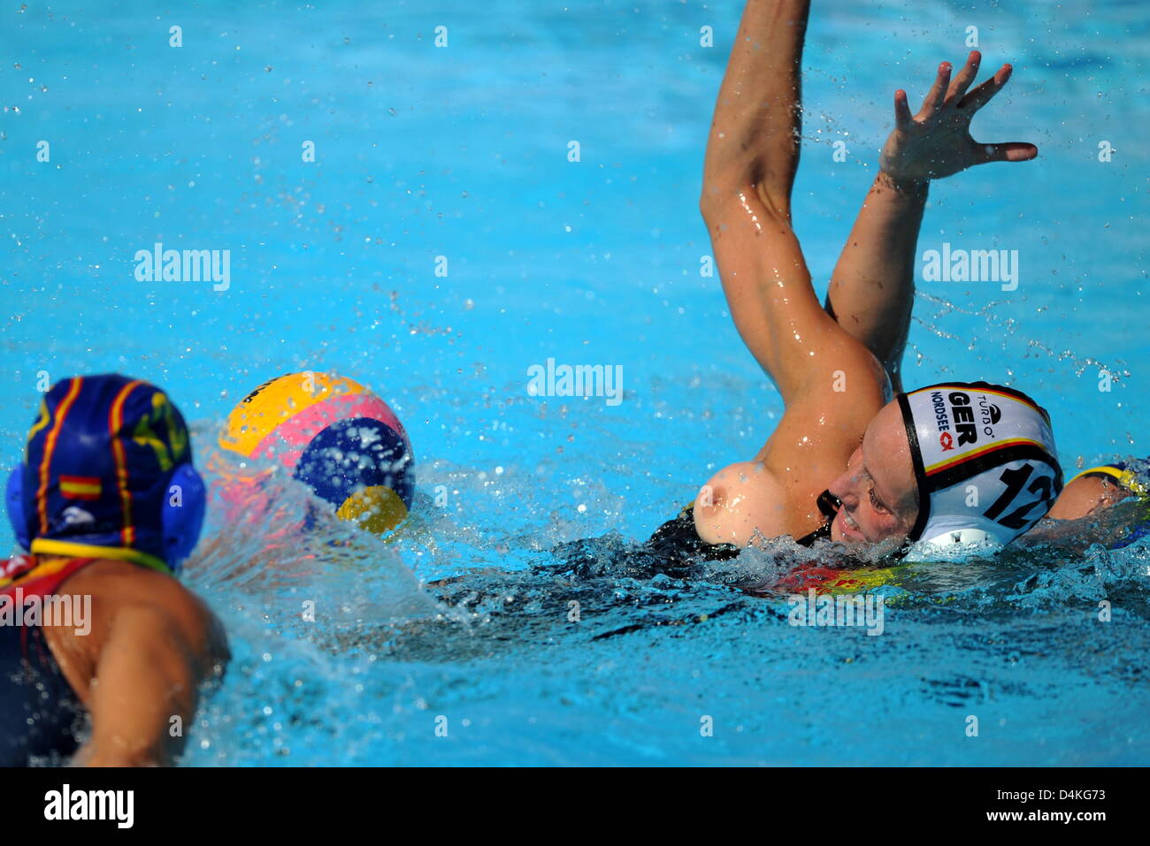 The breast of Germany?s Mandy Zollner (R) pops out while vying for the ball  with Spain?s Laura Lopez (L) during the Water Polo group D match Germany vs  Spain at the 13th