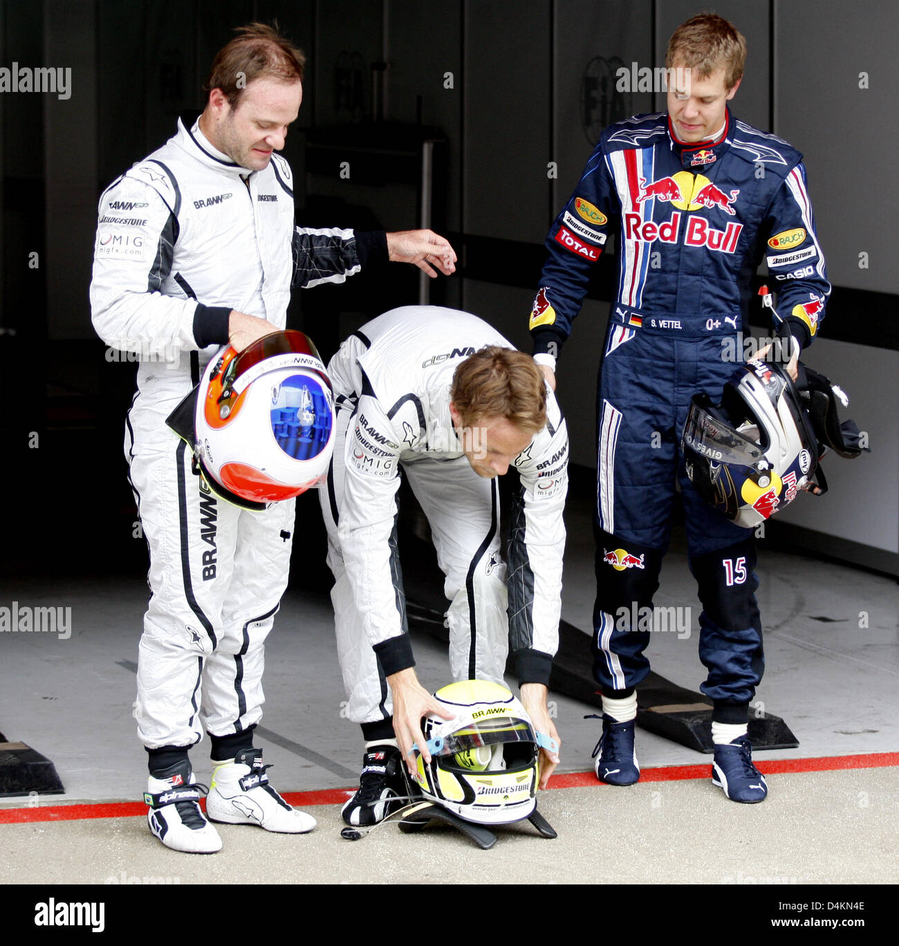 British Formula One driver Jenson Button of Brawn GP (C) puts his helmet on the ground next to German Formula One driver Sebastian Vettel of Red Bull (R) and Brazilian Formula One driver Rubens Barrichello of Brawn GP (L) after the qualifying at Circuit de Catalunya in Montmelo near Barcelona, Spain, 09 May 2009. The Formula One Grand Prix of Spain will take place on 10 May 2009. P Stock Photo