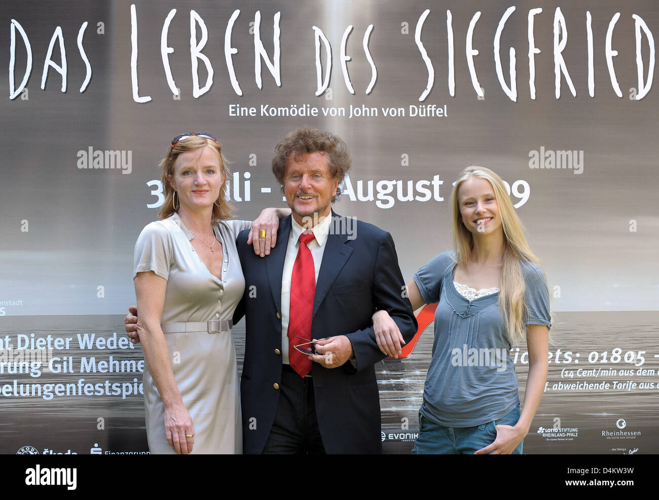 Dieter Wedel (C), artistic director of the Nibelungen Festival,  and actresses Nina Petri as ?Bruenhild? (L) and Susanne Bormann as ?Kriemhild? (R) stand in front of a poster of the festival during a press conference in Worms, Germany, 22 May 2009. The comedy ?The Life of Siegfried? by best-selling author John von Dueffel will be staged for the first time between 31 July and 16 Aug Stock Photo