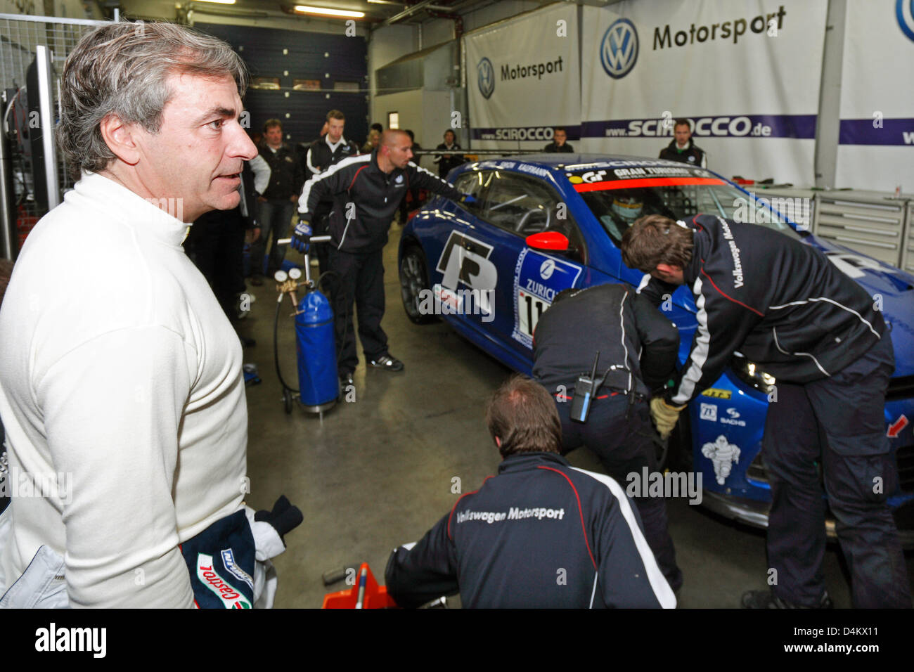 Rallye world champion Spanish Carlos Sainz (L) watches his crew service the VW Scirocco during the Nuerburgring 24 hours race, Nuerburgring, Germany, 24 May 2009. Photo: Thomas Frey Stock Photo