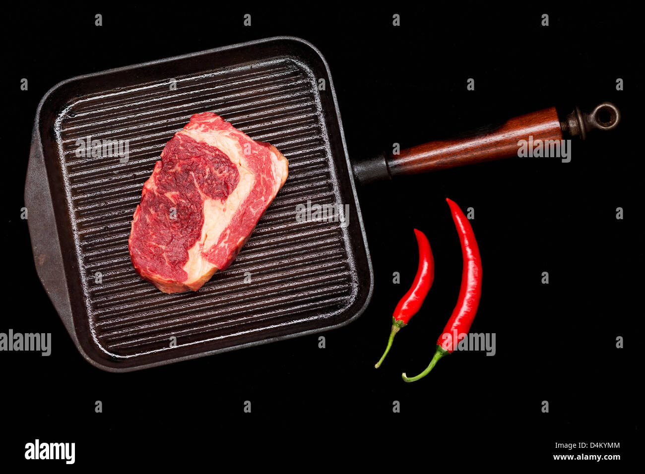 Meat in grill pan with chili peppers Stock Photo Alamy
