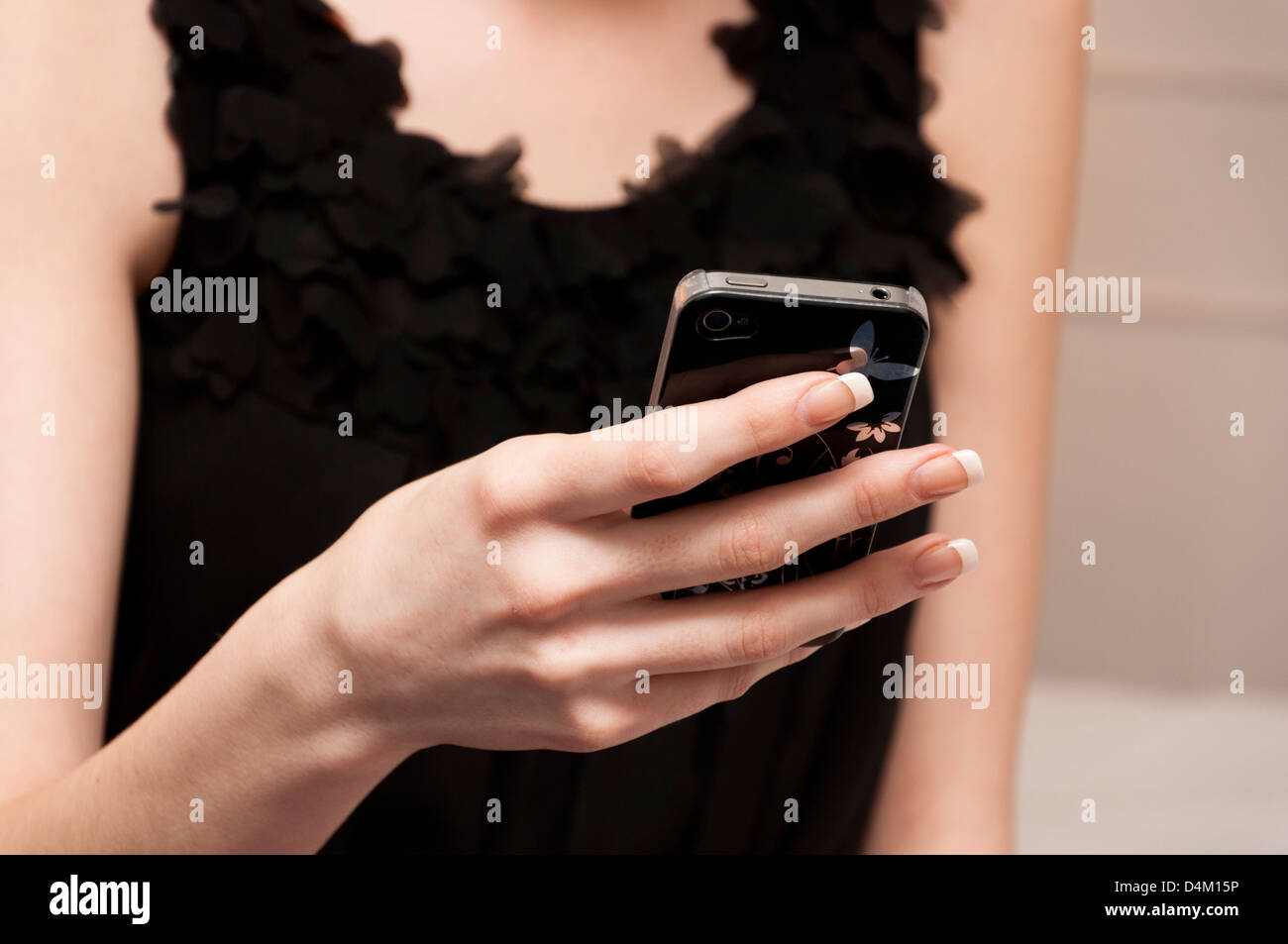 Pretty girl in little black checking her mobile phone Stock Photo