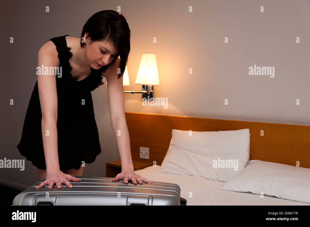 Woman packing suitcase in hotel room Stock Photo