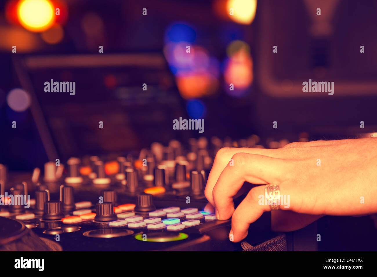 DJ behind the decks in night club Stock Photo