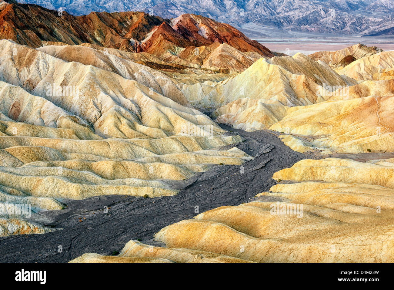 Civil twilight bathes the badlands of Golden Canyon in California's Death Valley National Park. Stock Photo