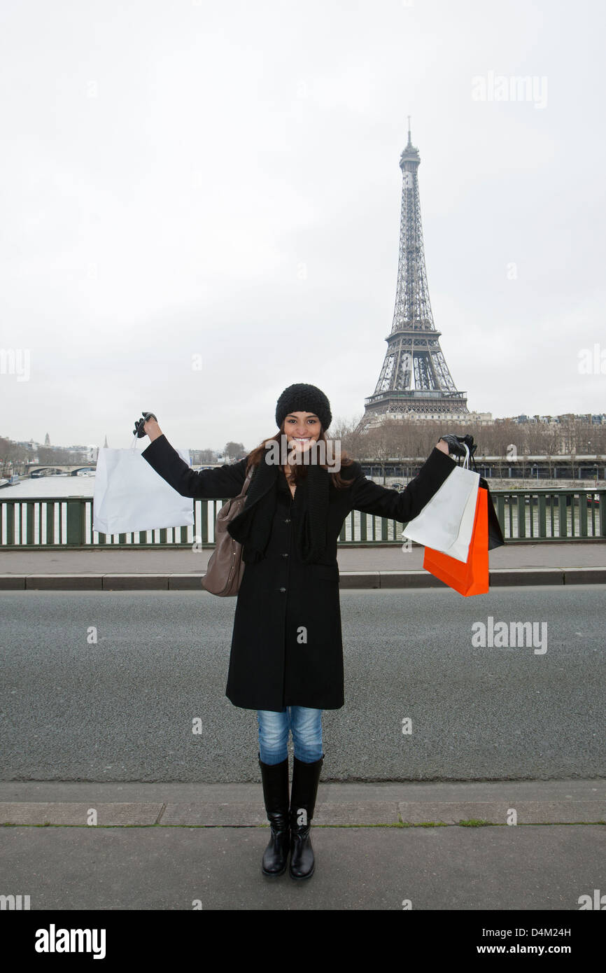 Woman with shopping bags by Eiffel Tower Stock Photo