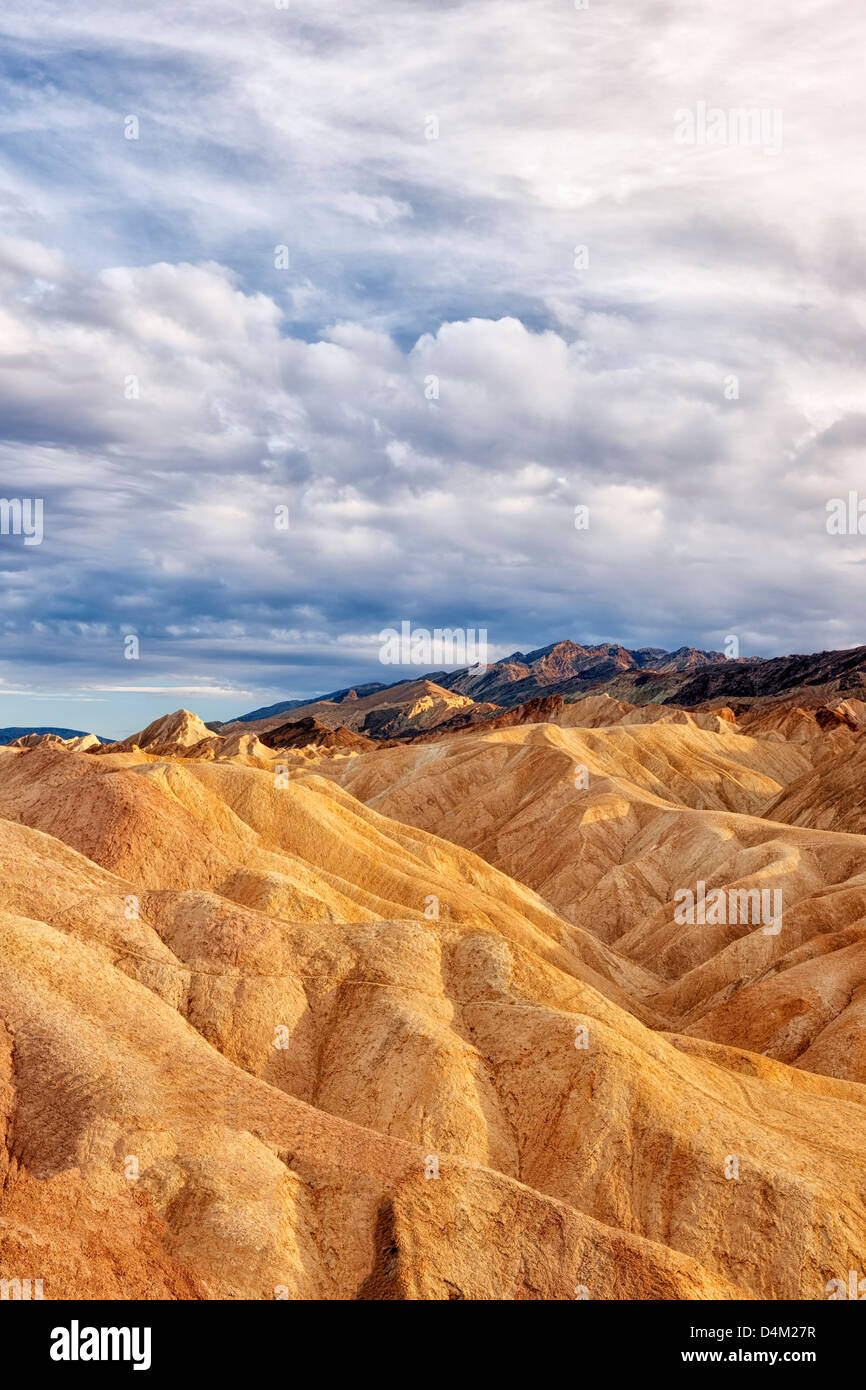Dappled evening light bathes the badlands of Golden Canyon and California's Death Valley National Park. Stock Photo