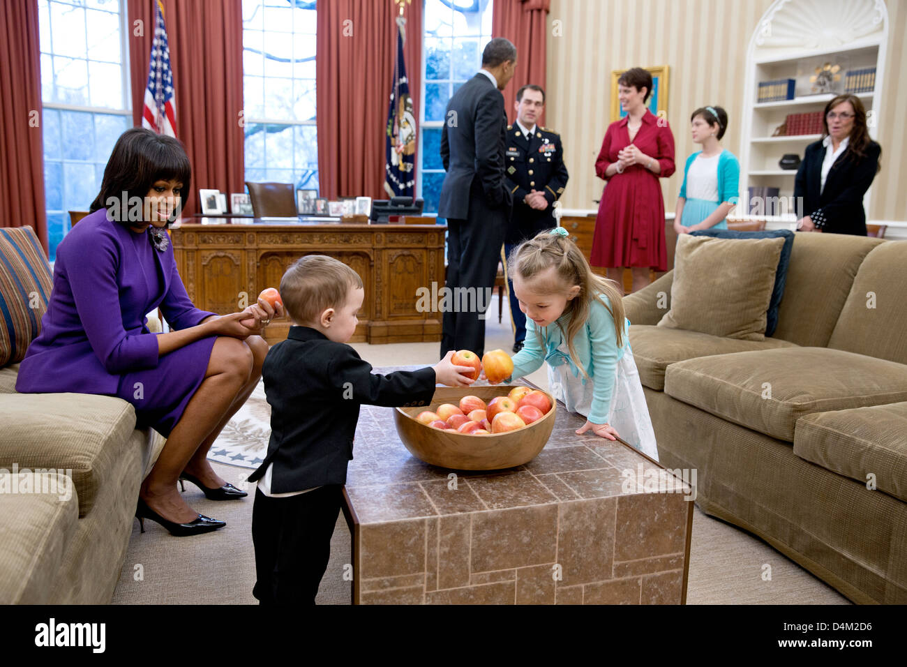 US President Barack Obama and First Lady Michelle Obama visit with former Staff Sergeant Clinton Romesha and his family in the Oval Office prior to a ceremony to award Romesha the Medal of Honor February 11, 2013 in Washington, DC. Remesha's family members, from left, are: son Colin Romesha, 2; daughter Gwen Romesha, 4; wife Tammy Romesha, daughter Dessi Romesha, 11; and mother Tish Rogers. Stock Photo
