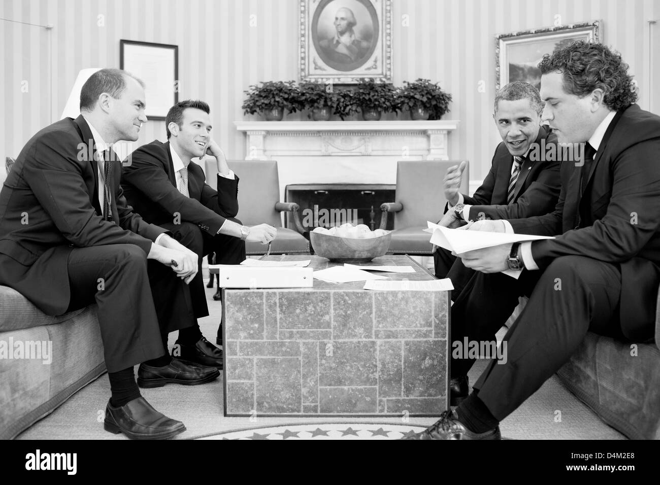US President Barack Obama works on his State of the Union address with staff in the Oval Office February 12, 2013 in Washington, DC. Seated, from left, are: Ben Rhodes, Deputy National Security Advisor for Strategic Communications; Director of Speechwriting Jon Favreau; and Cody Keenan, Deputy Director of Speechwriting. Stock Photo