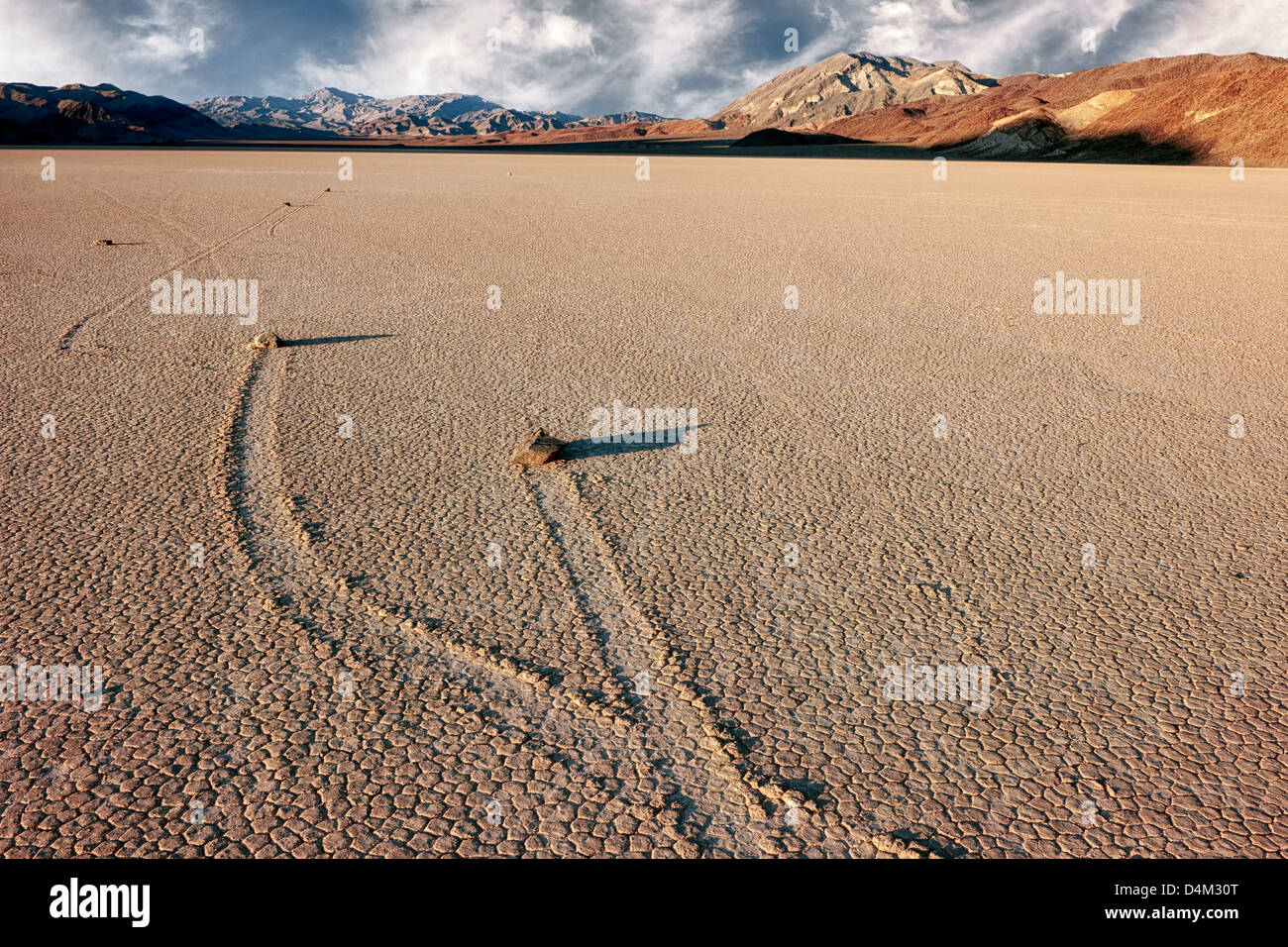 Moving rocks at The Racetrack leave trail imprints in the playa of California's Death Valley National Park. Stock Photo