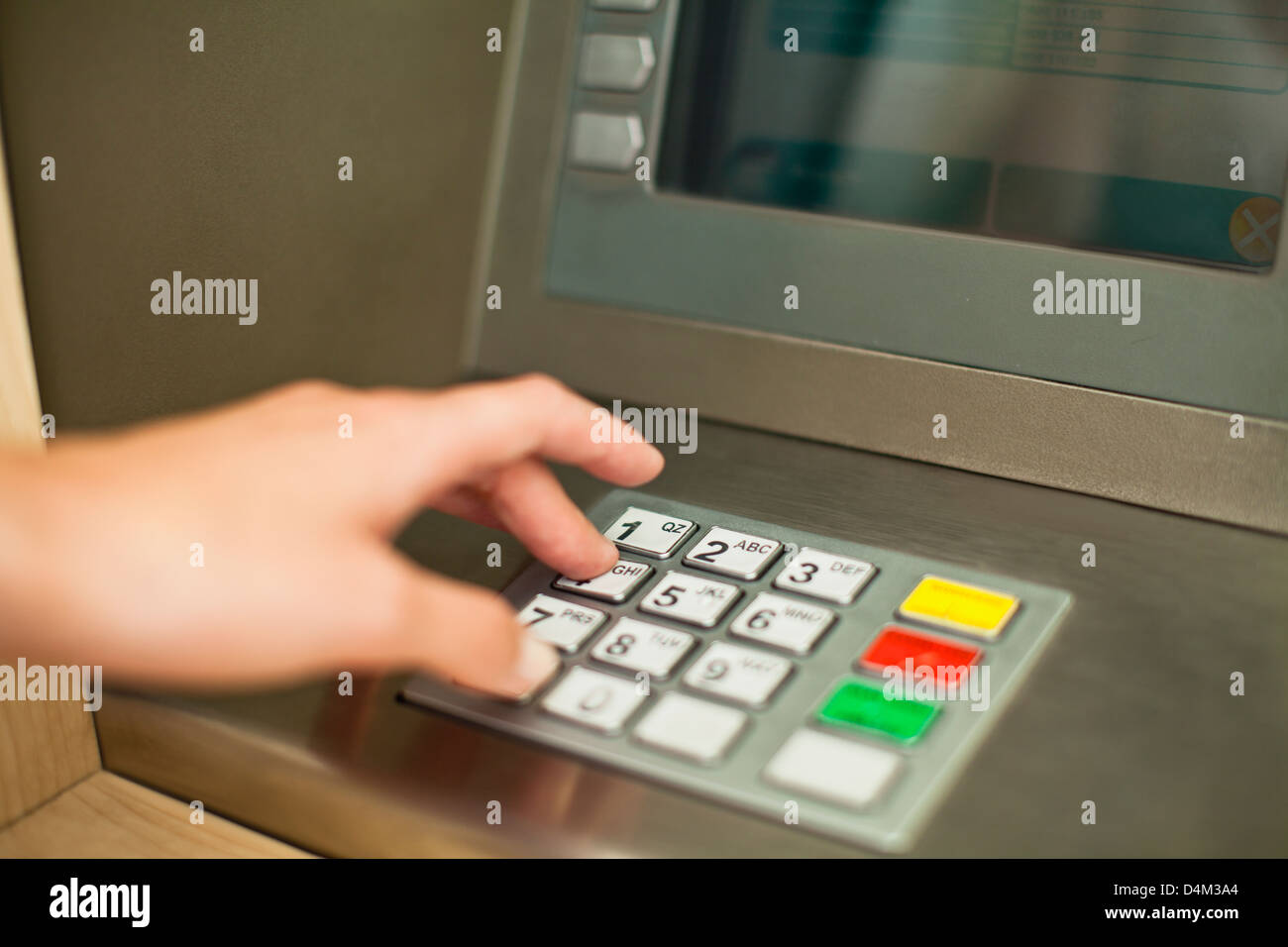 Woman using keypad on ATM Stock Photo