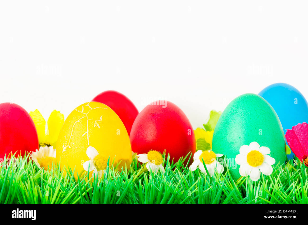 Easter Eggs on grass with flowers around Stock Photo