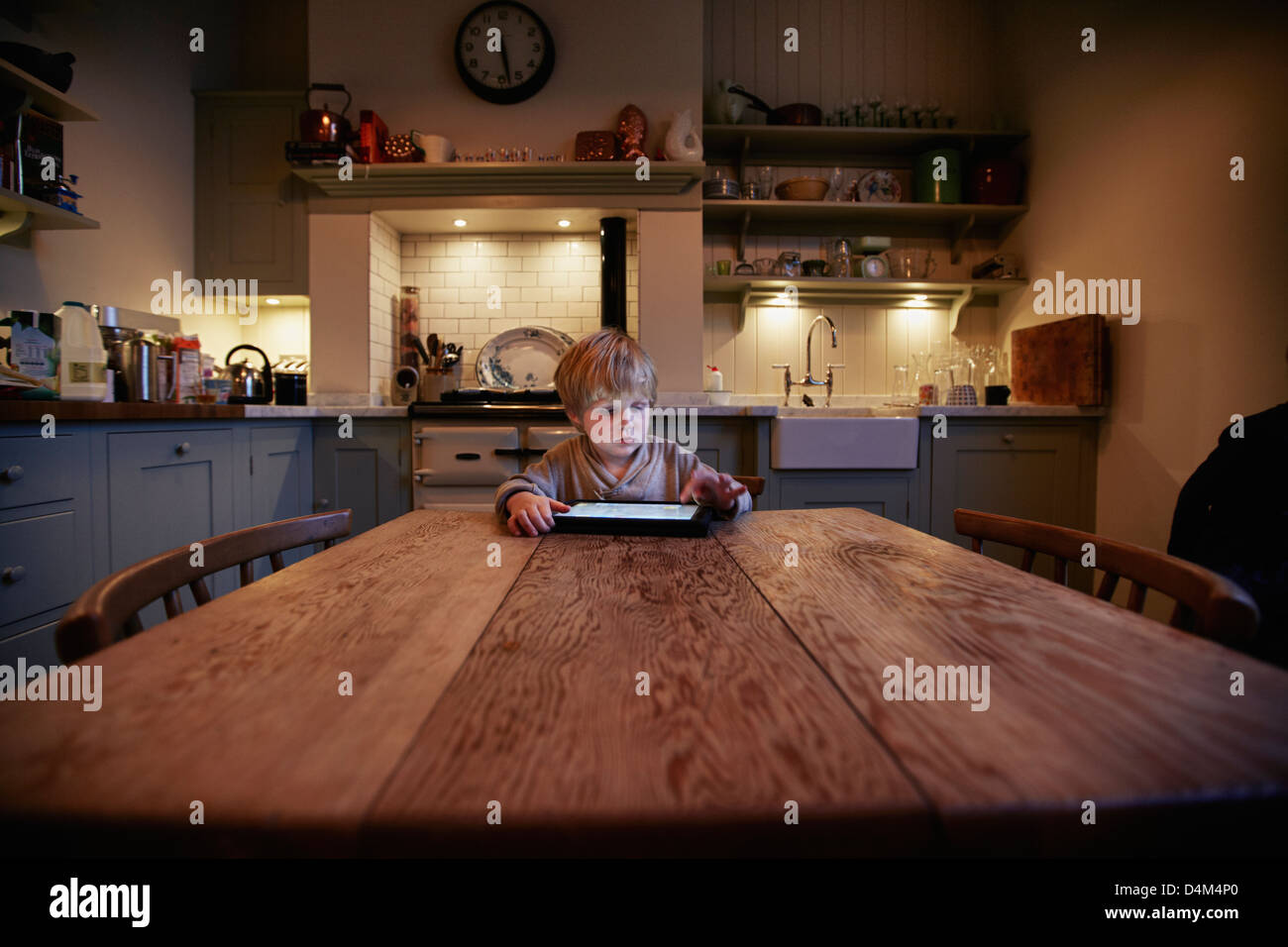 Boy using tablet computer at table Stock Photo