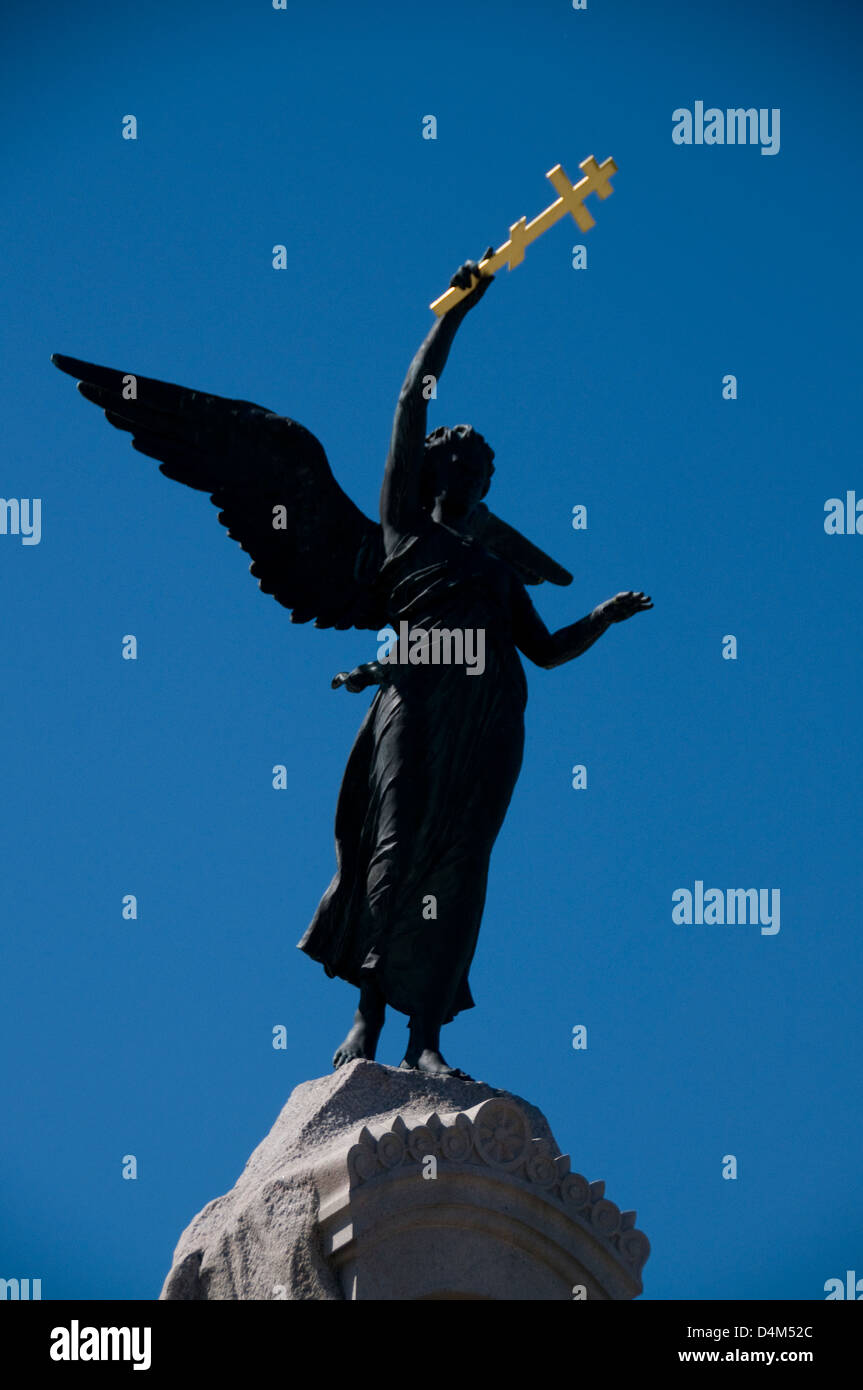 A bronze statue of an angel holding an Orthodox cross on the Russalka Memorial facing the Baltic Sea in Tallinn, Estonia Stock Photo