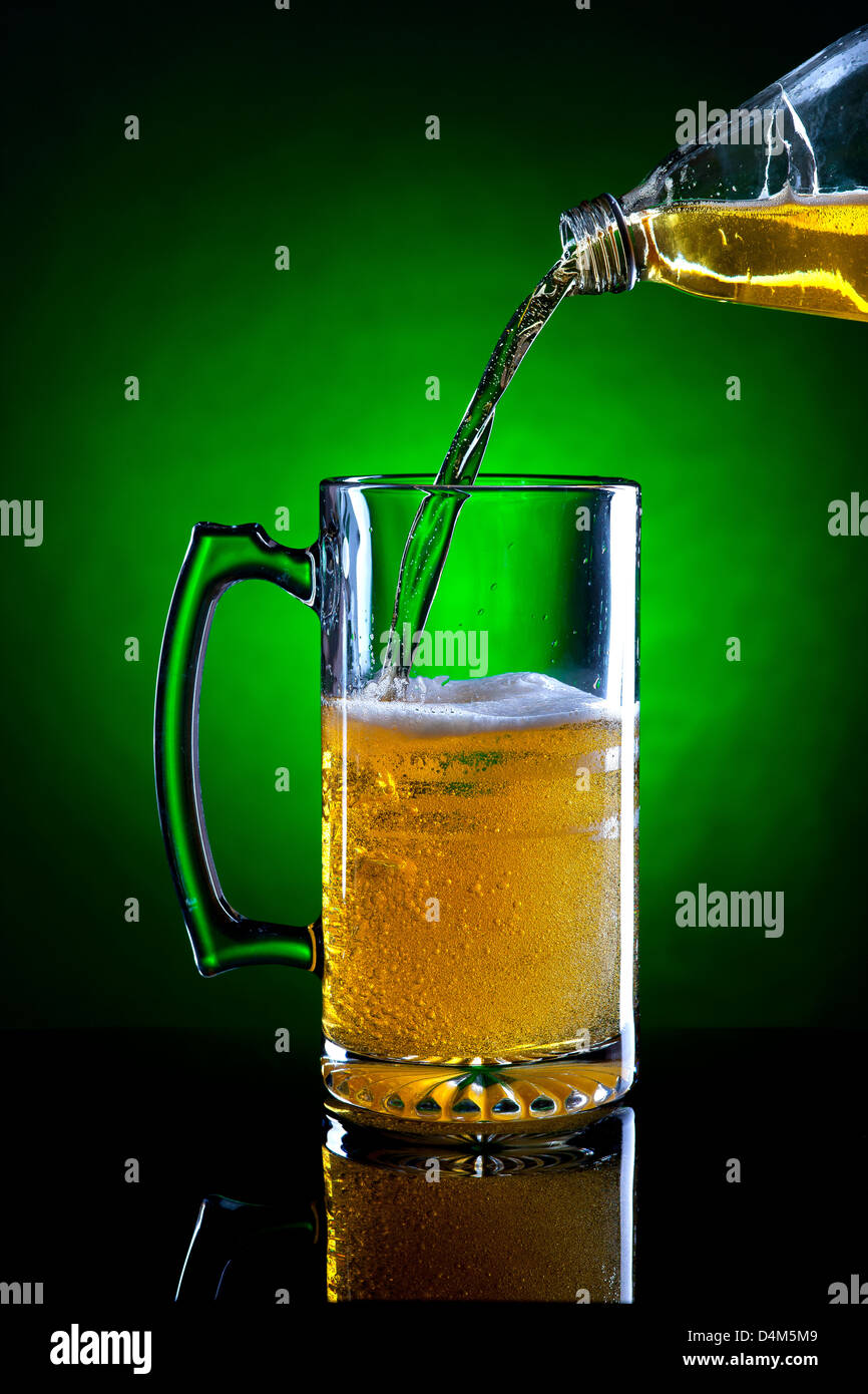 Pouring beer from a bottle. Stock Photo