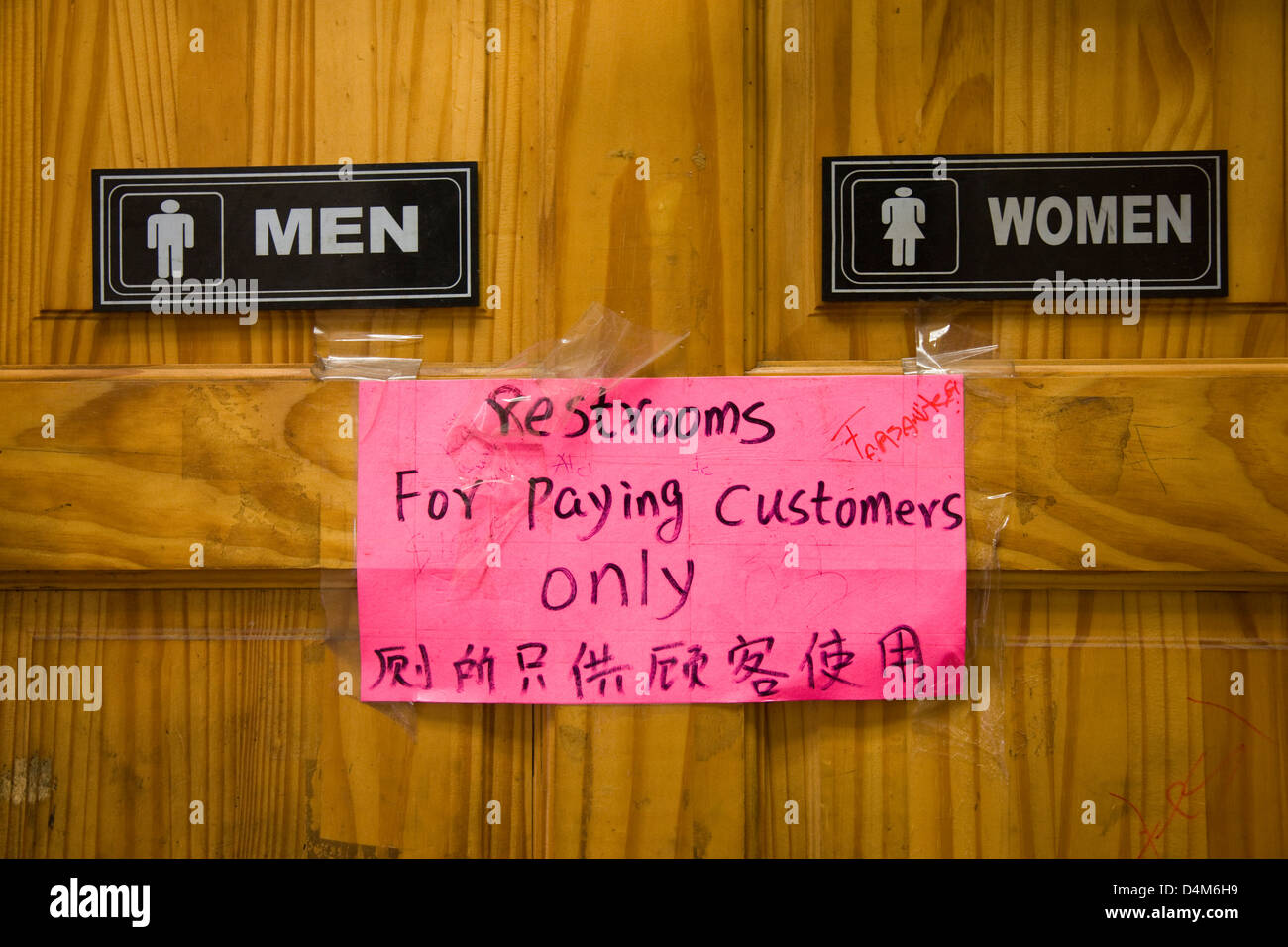 Men and women toilets or restrooms with sign 'for paying customers only' in Chinatown, New York Stock Photo