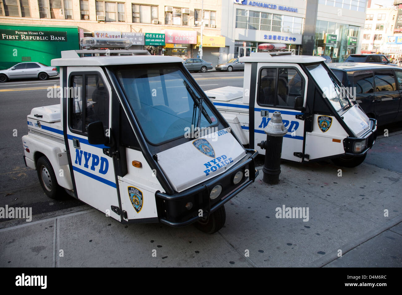 Tiny electric NYPD police patrol three wheeled cars parked in Chinatown, New York Stock Photo
