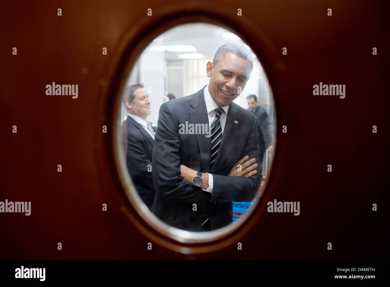 US President Barack Obama is seen through a door to the pantry near the State Dining Room of the White House as he waits to meet with the National Governors Association February 25, 2013 in Washington, DC. Stock Photo