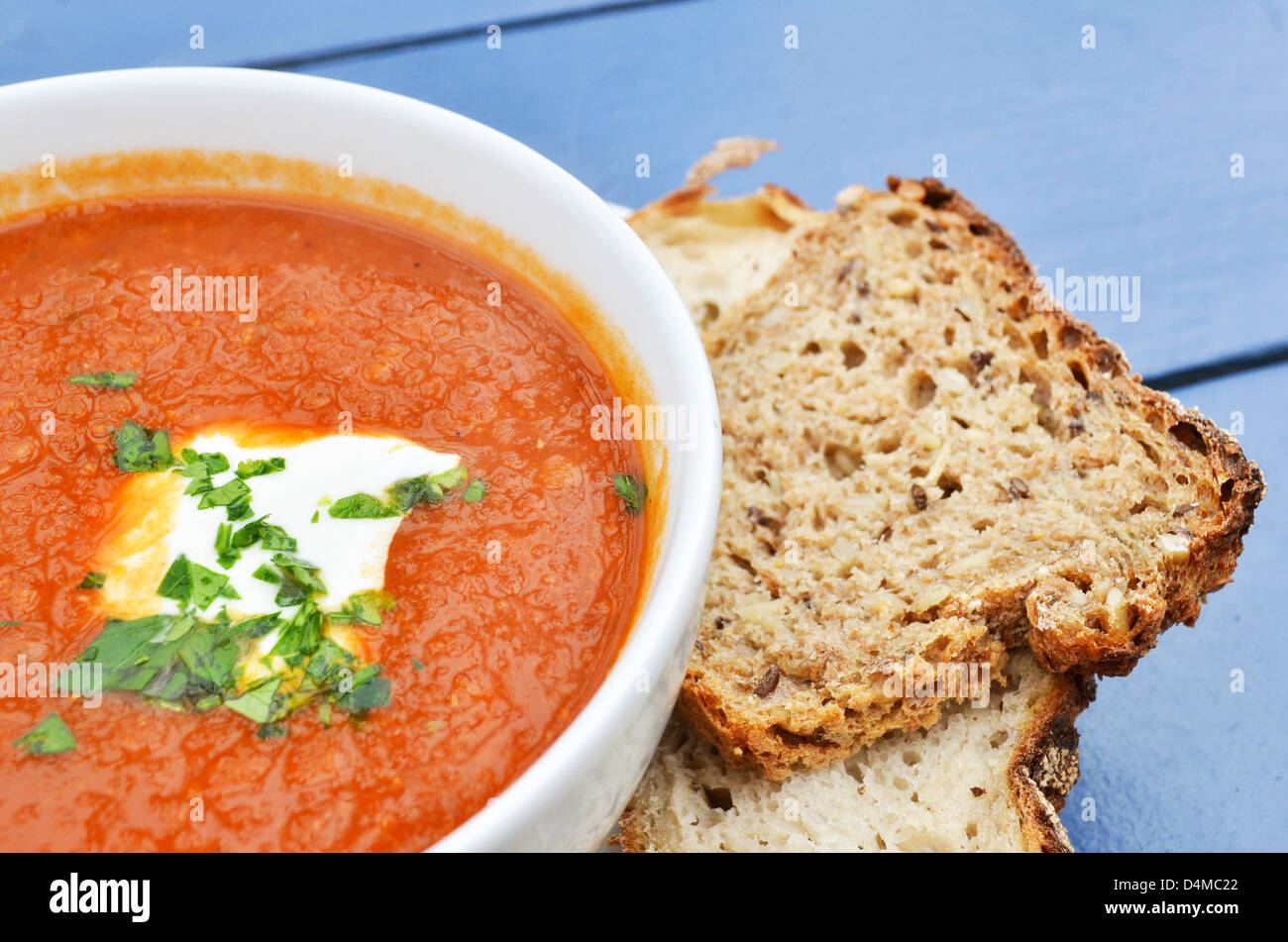 Tomato soup with basil and fresh black bread closeup Stock Photo