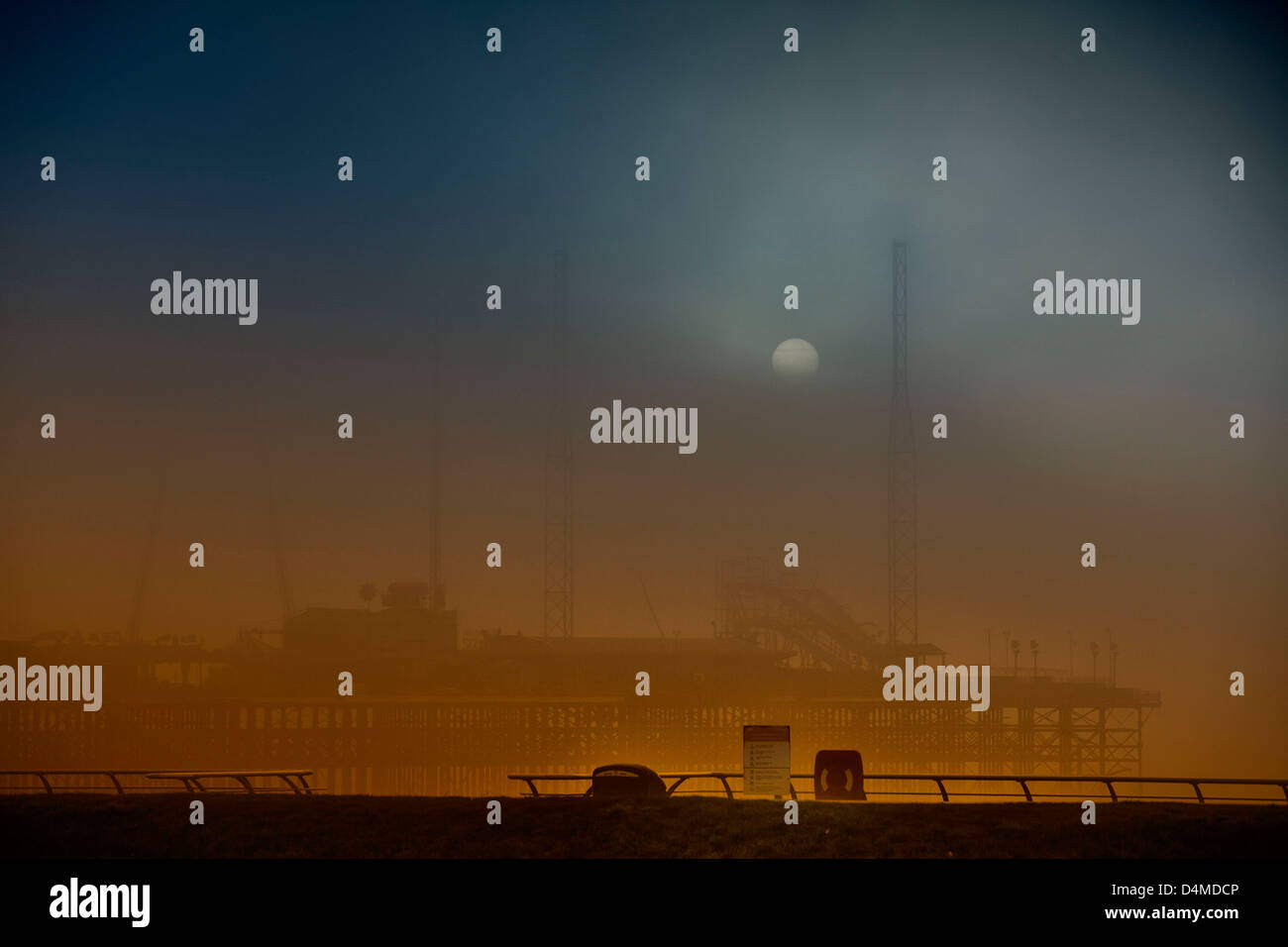 Sun breaking threw a gap in the winter fog that was rolling  in over the South Pier Blackpool. Stock Photo
