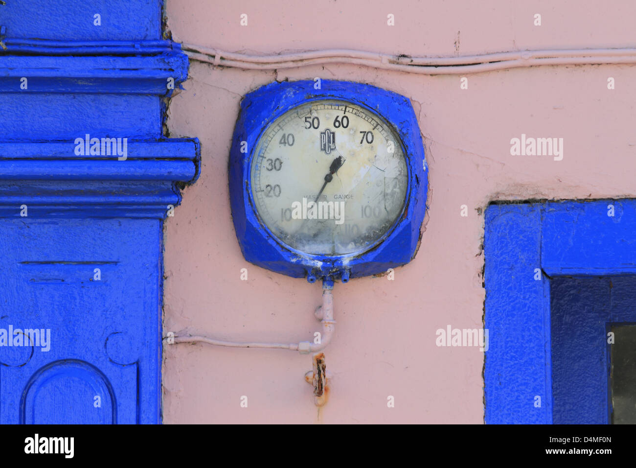 Old blue clock face on bright pink wall Schull Co County Cork west of Ireland Stock Photo