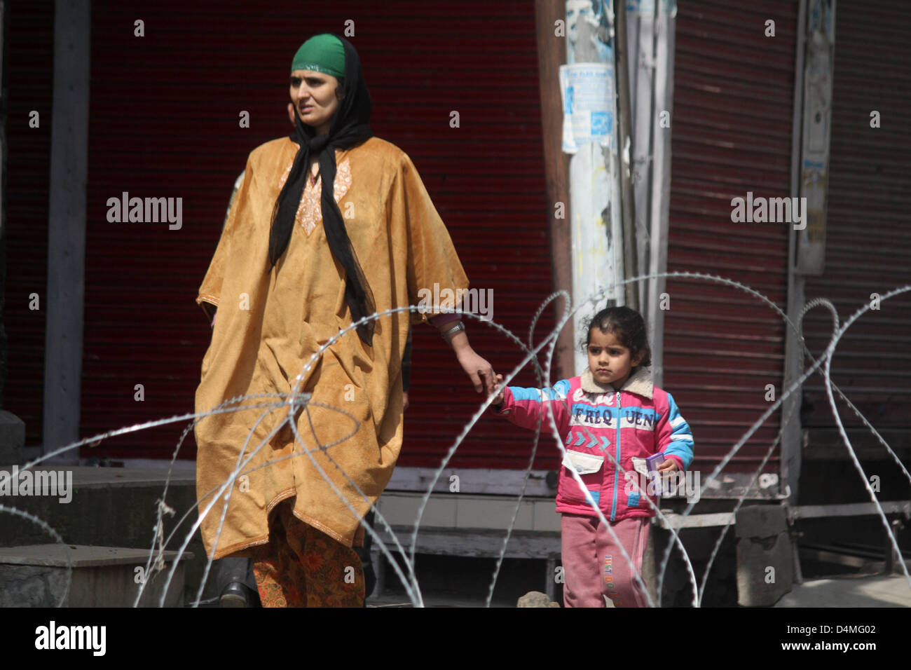 March 16, 2013 - A kasmiri muslim women walks with her child during  curfew at old city  in srinagar, the summer capital of indian kashmir , on 16/3/2013,Curfew was imposed on Thursday after a 34-year-old youth was killed when Indian paramilitary soldiers allegedly opened fire after coming under attack by a group of stone pelters in the Zoonimar area..Photo/Altaf Zargar/Zuam Press (Credit Image: © Altaf Zargar/ZUMAPRESS.com) Stock Photo