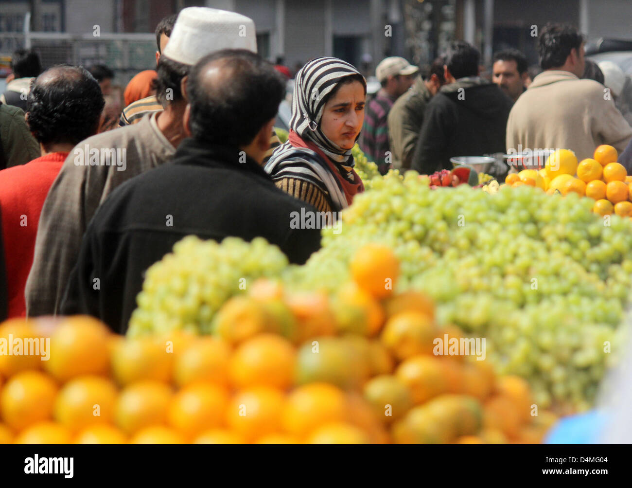 March 16, 2013 - A kasmiri muslim women Buying  fruits at a market  after the  Releaxation of curfew in srinagar, the summer capital of indian kashmir , on 16/3/2013,Curfew was imposed on Thursday after a 34-year-old youth was killed when Indian paramilitary soldiers allegedly opened fire after coming under attack by a group of stone pelters in the Zoonimar area..Photo/Altaf Zargar/Zuam Press (Credit Image: © Altaf Zargar/ZUMAPRESS.com) Stock Photo