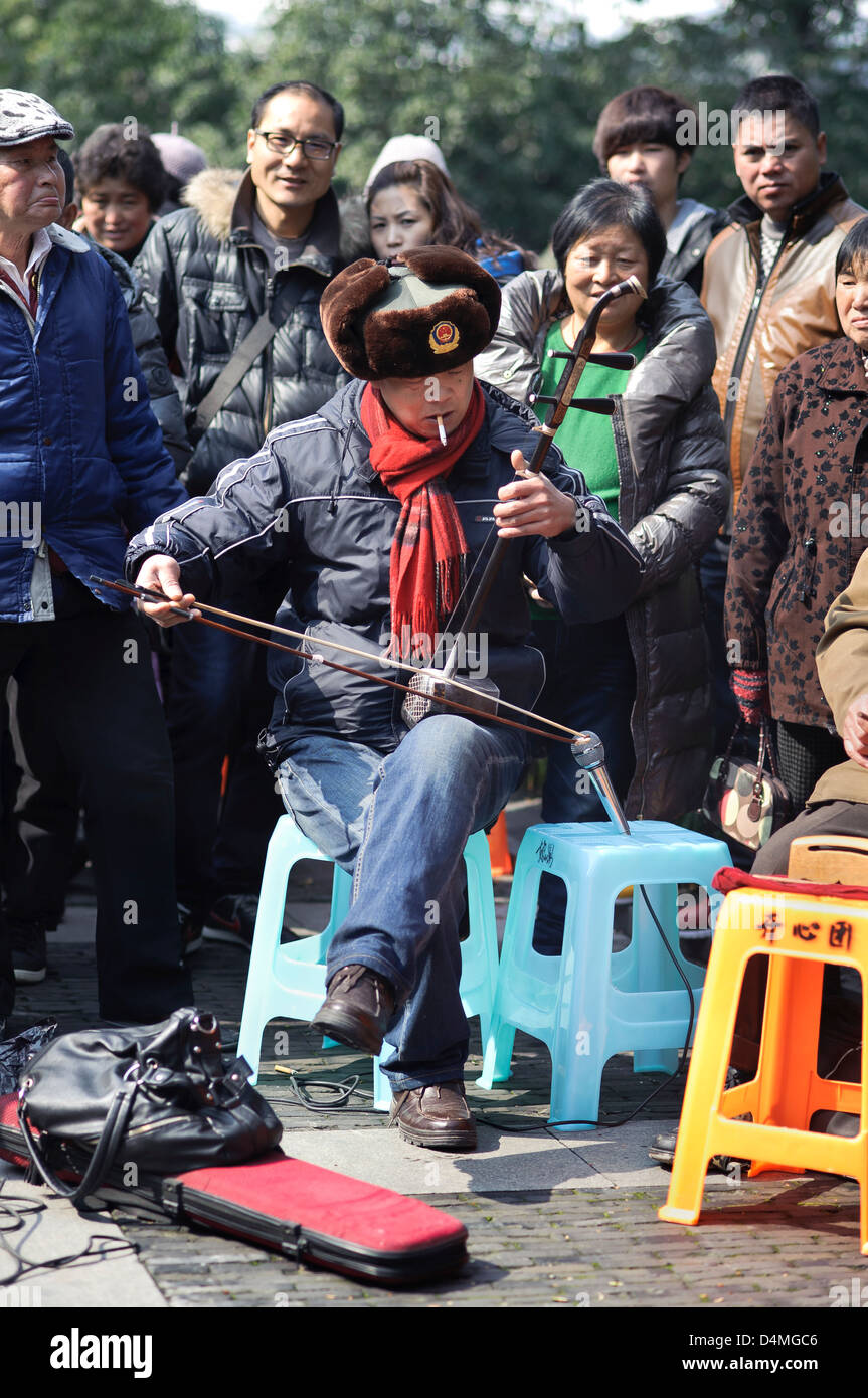 A man plays the traditional Chinese stringed instrument the Erhu beside West Lake in Hangzhou, China Stock Photo