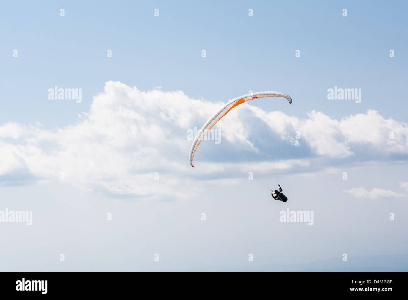 Paragliding over the mountain against blue sky Stock Photo