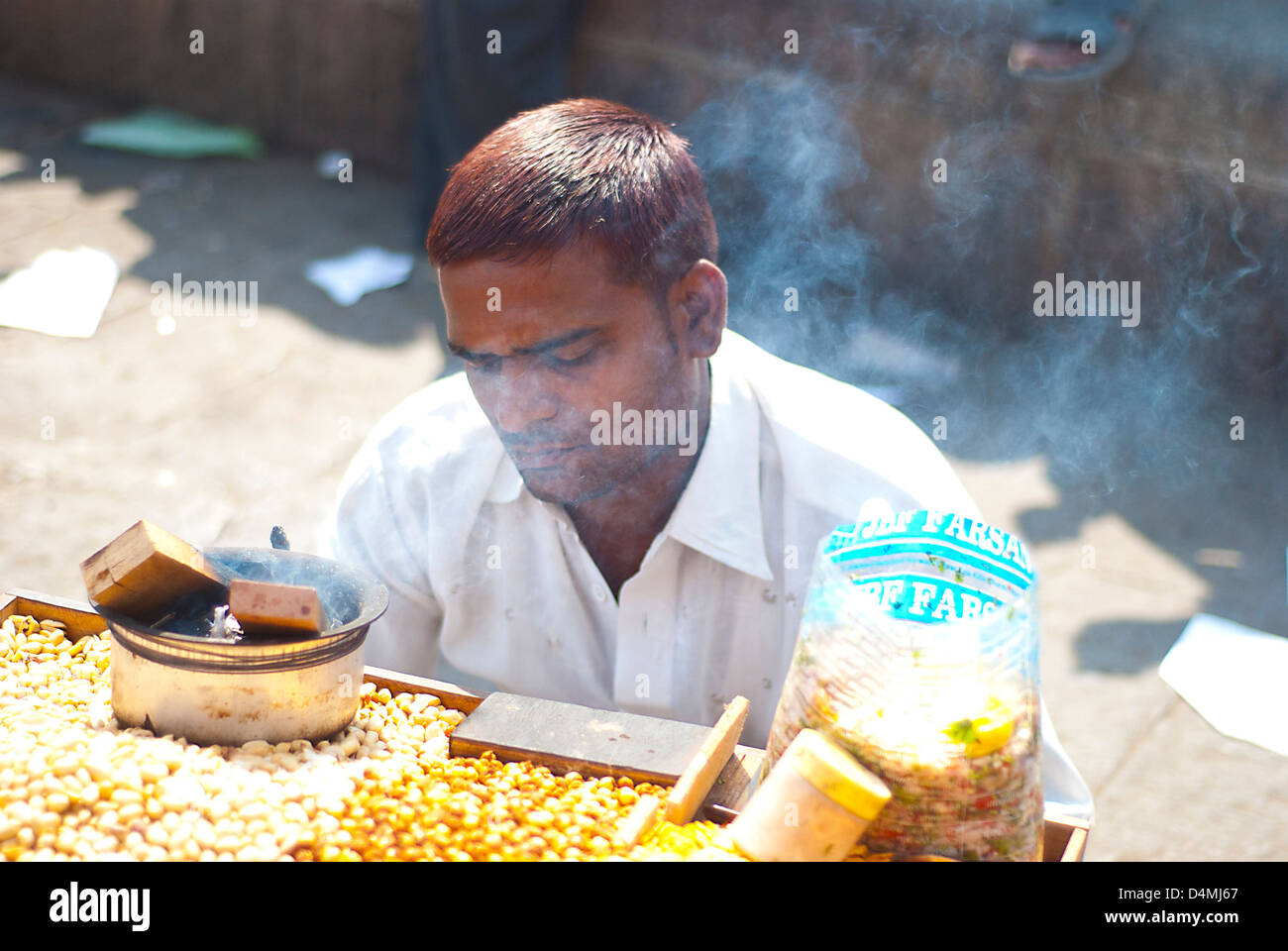 An indian man sells corn on a street in Mumbai, india Stock Photo