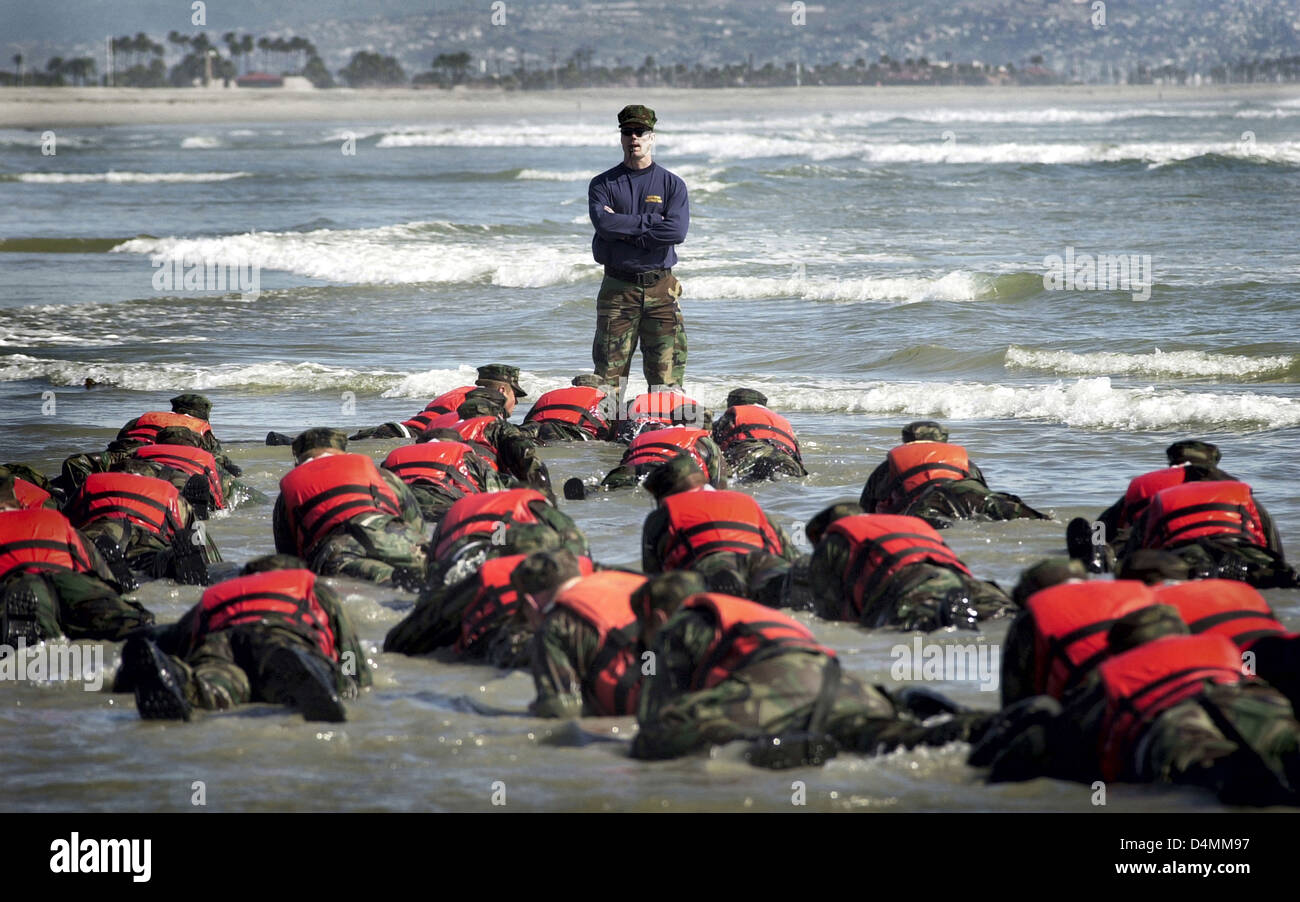 US Navy SEAL recruits participate surf drill evolution training during Hell Week April 15, 2003 in Coronado, CA. SEAL training lasts six months and hell week is five-and-a-half days of continuous training with very little sleep designed to push recruits to the limits. Stock Photo