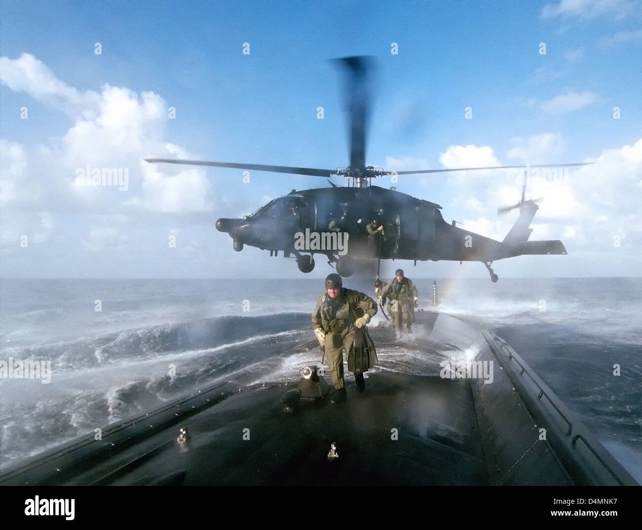 Members of the US Navy SEALs practice water insertion techniques dropped by Black Hawk helicopter to the deck of a submarine March 4, 2012. Stock Photo