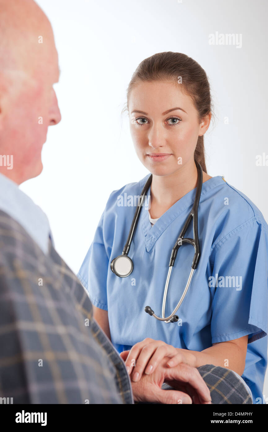 Elderly male patient being comforted by young female nurse/doctor. Stock Photo