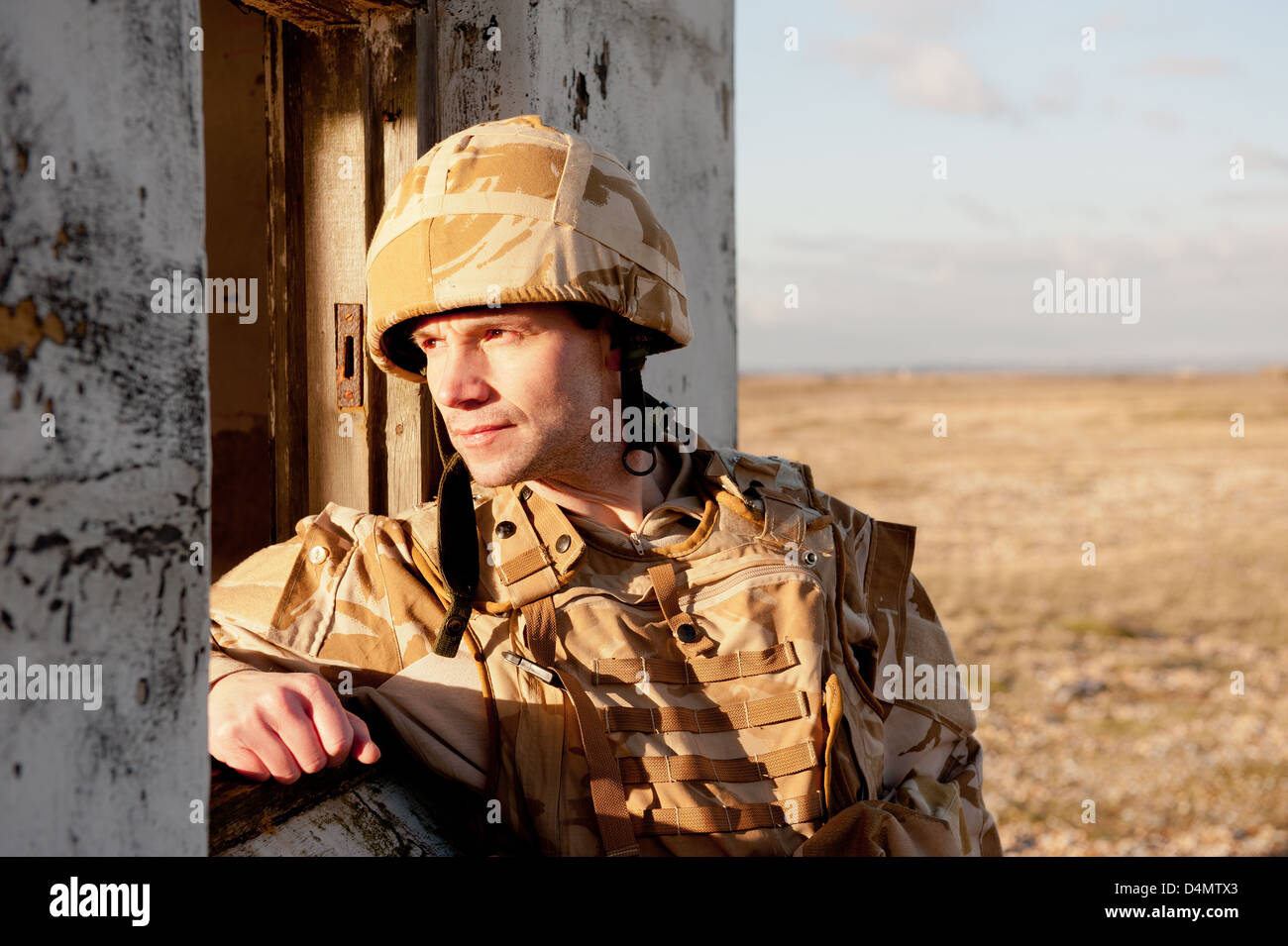 British soldier wearing desert camouflage uniform and looking through