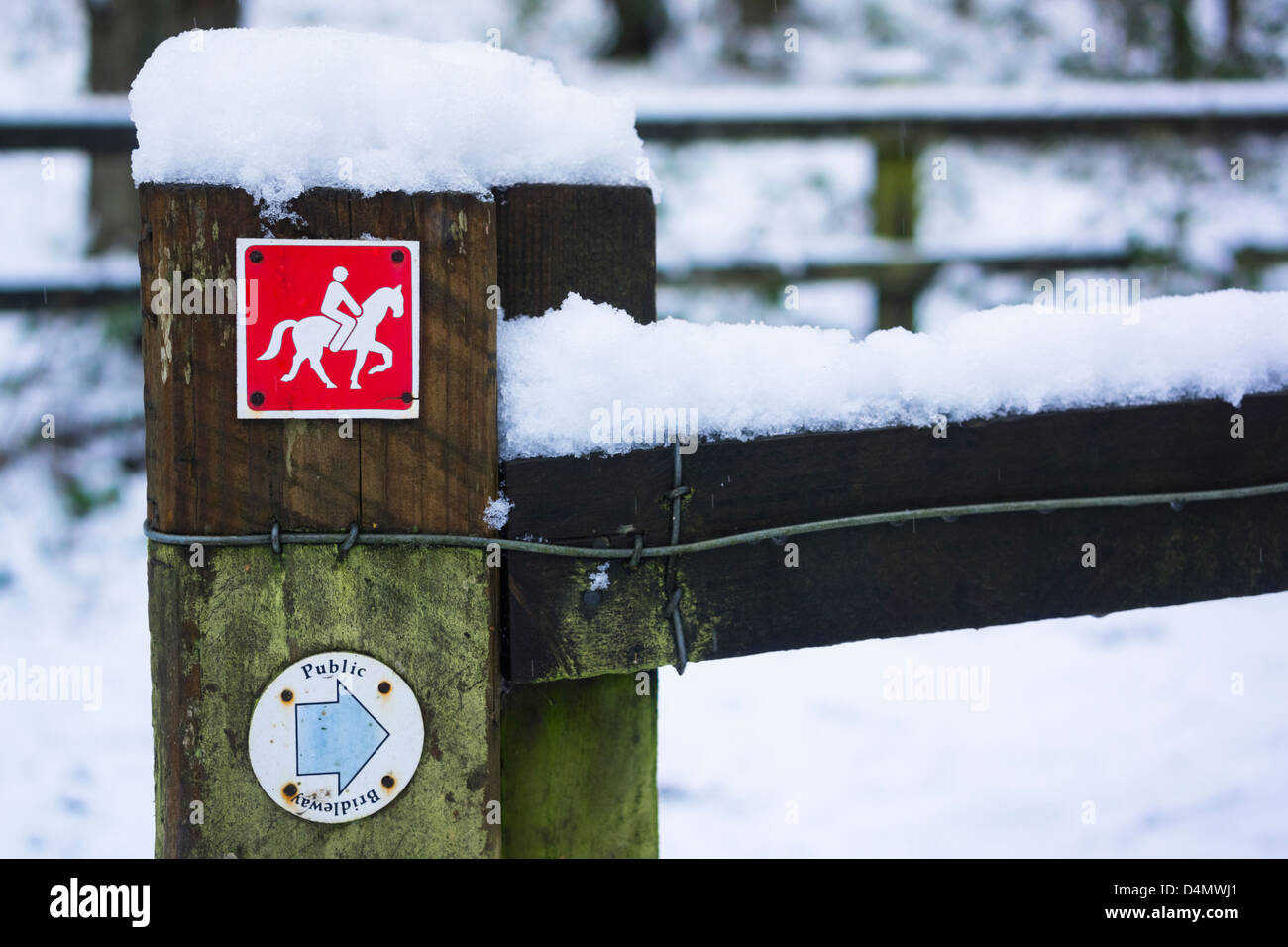 A red bridleway sign on a fence in winter. Stock Photo