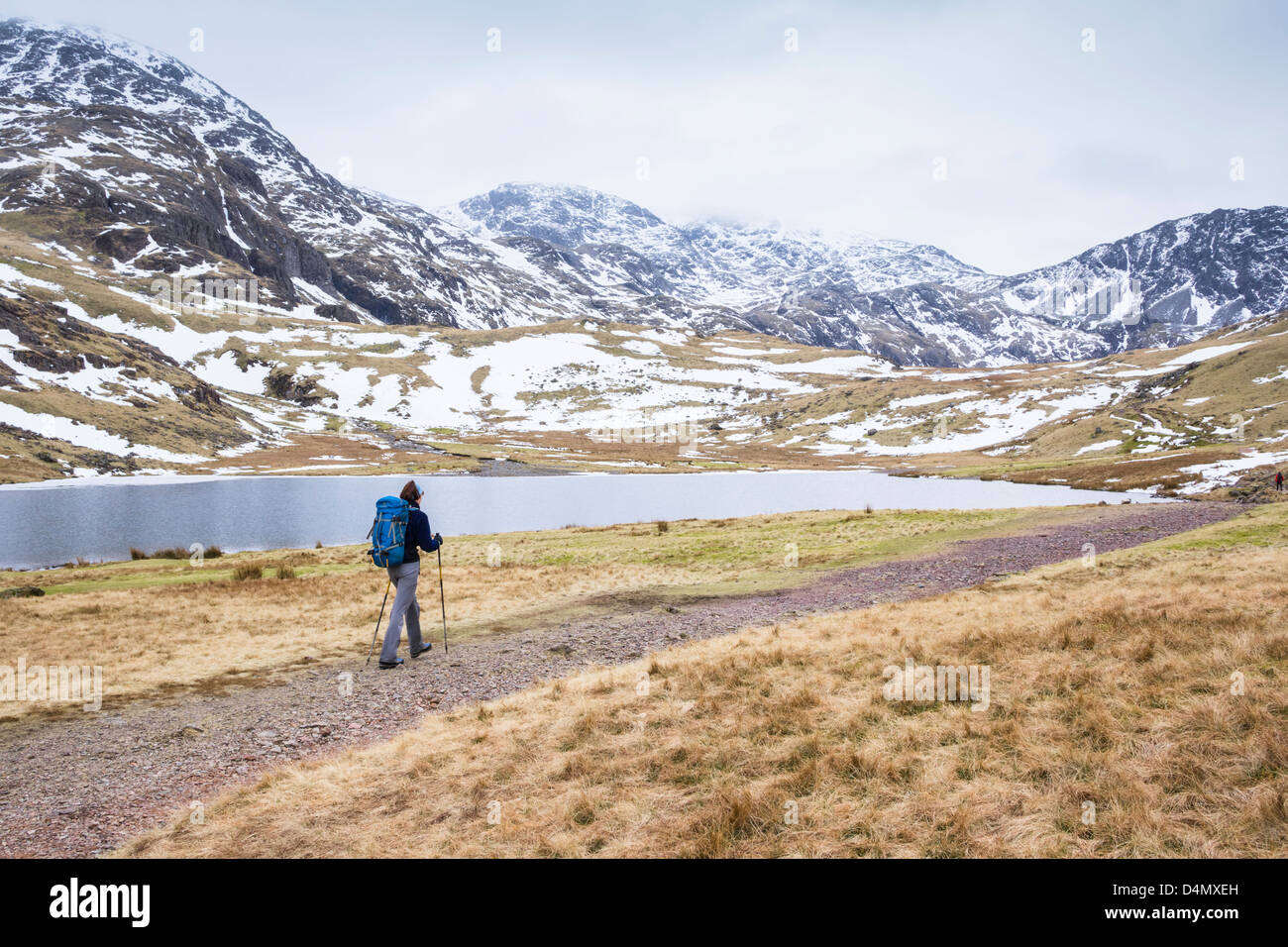 A hiker approaching Styhead Tarn below Great End in the Lake District. Stock Photo