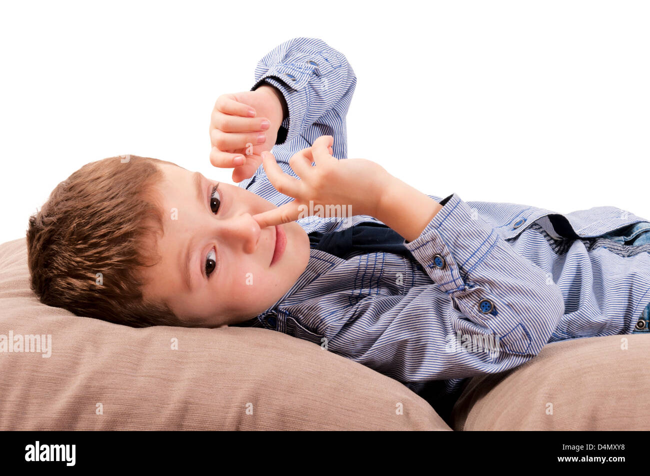The boy digs nose and lie down on pillows Stock Photo Alamy