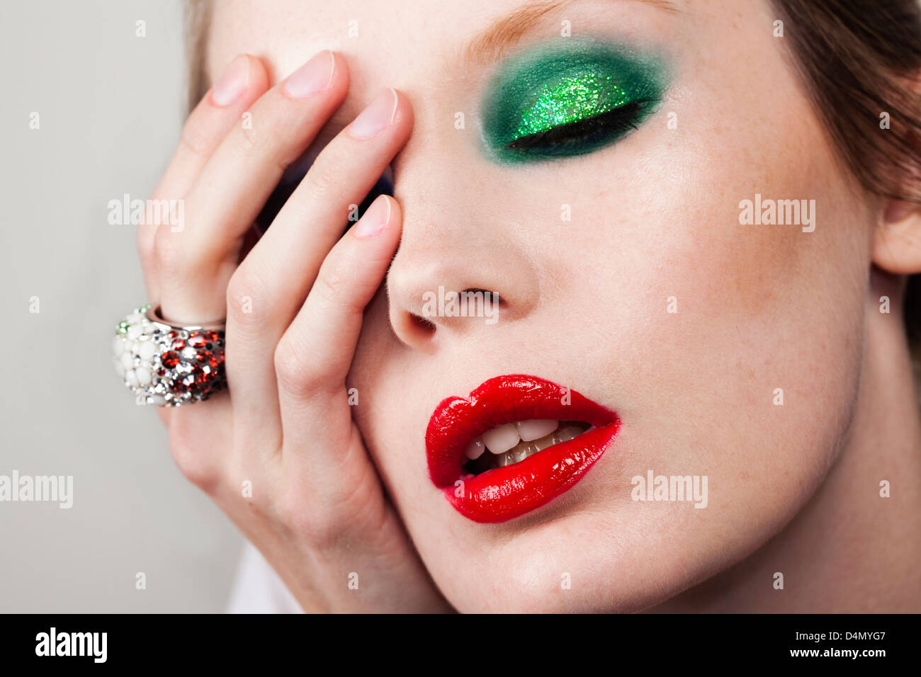 Female model wearing green eye shadows and red lips Stock Photo