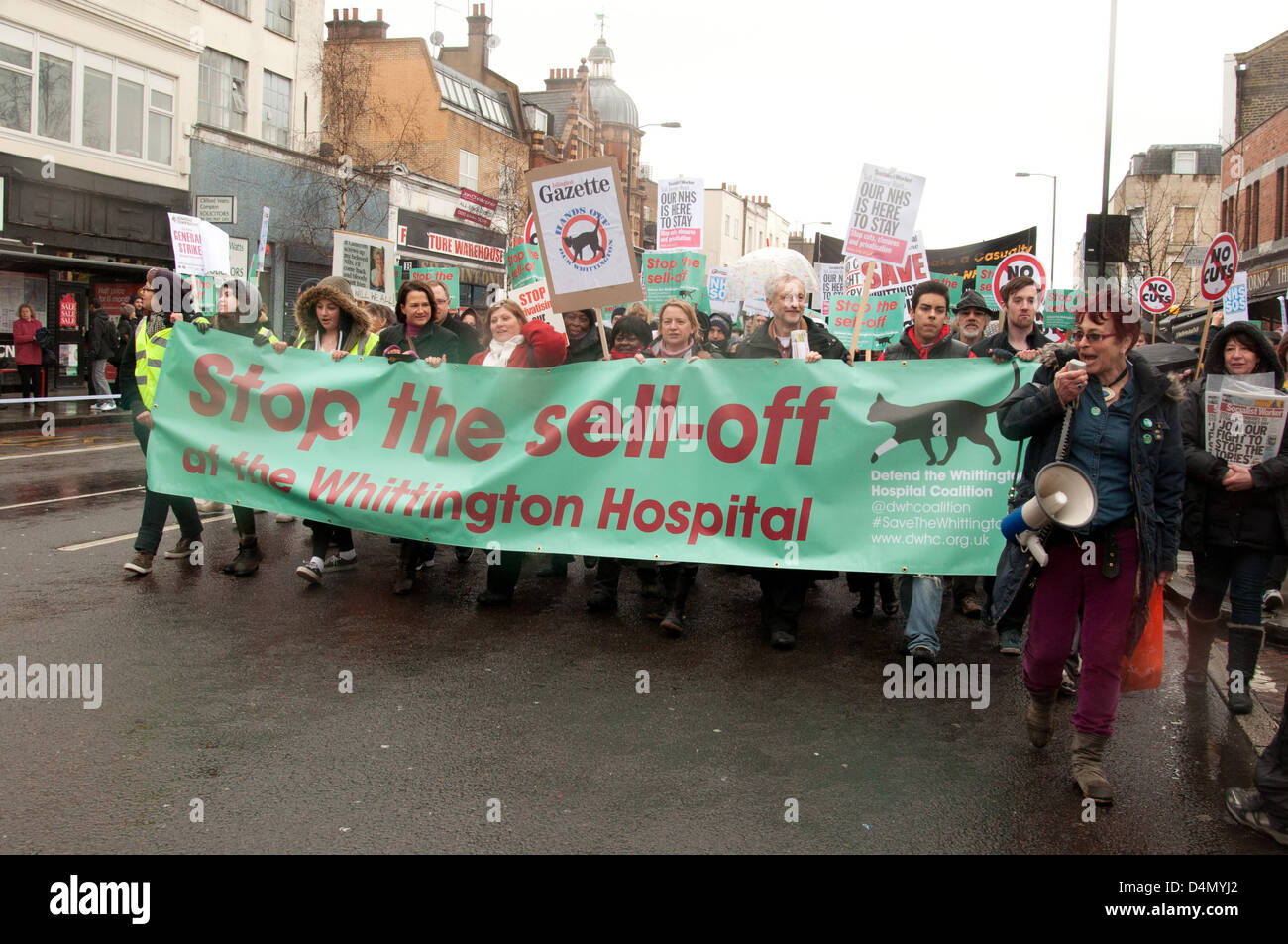 London UK, 16th March 2013. Thousands of people campaigning to stop the cuts at the Whittington Hospital march through an overcast, rainy Islington before arriving at the Hospital itself. The board of the Whittington Hospital Trust have controversial plans for budget cuts, which include selling off one third of the site, closing beds and services and losing over five hundred jobs. Stock Photo