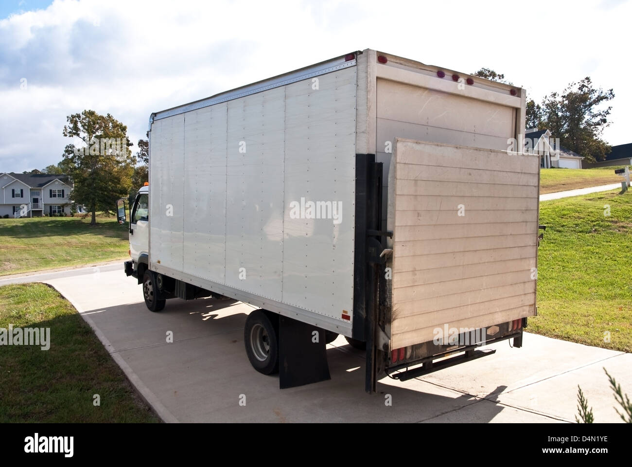 A large appliance delivery truck in the driveway of a home. Stock Photo