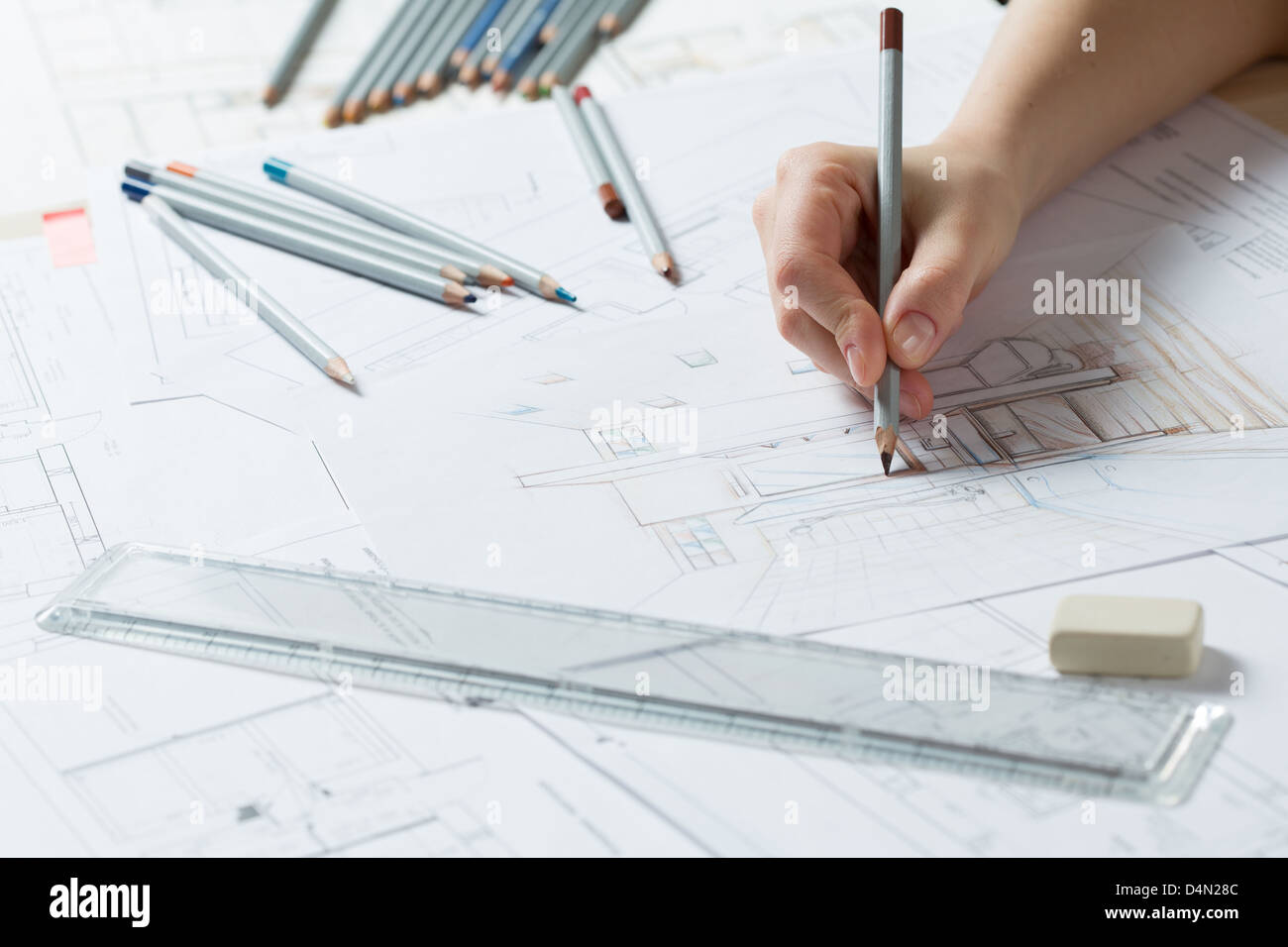 Interior designer works on a hand drawing sketch using color pencils, rule and rubber Stock Photo