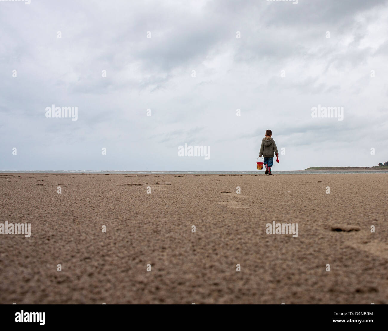 boy on a beach in Borth wales with his bucket and spade Stock Photo