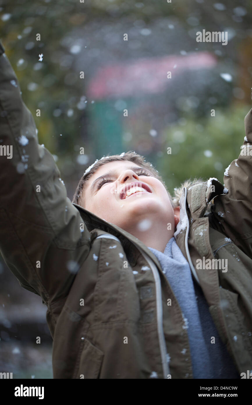 A happy boy try to catch snowflakes. Stock Photo