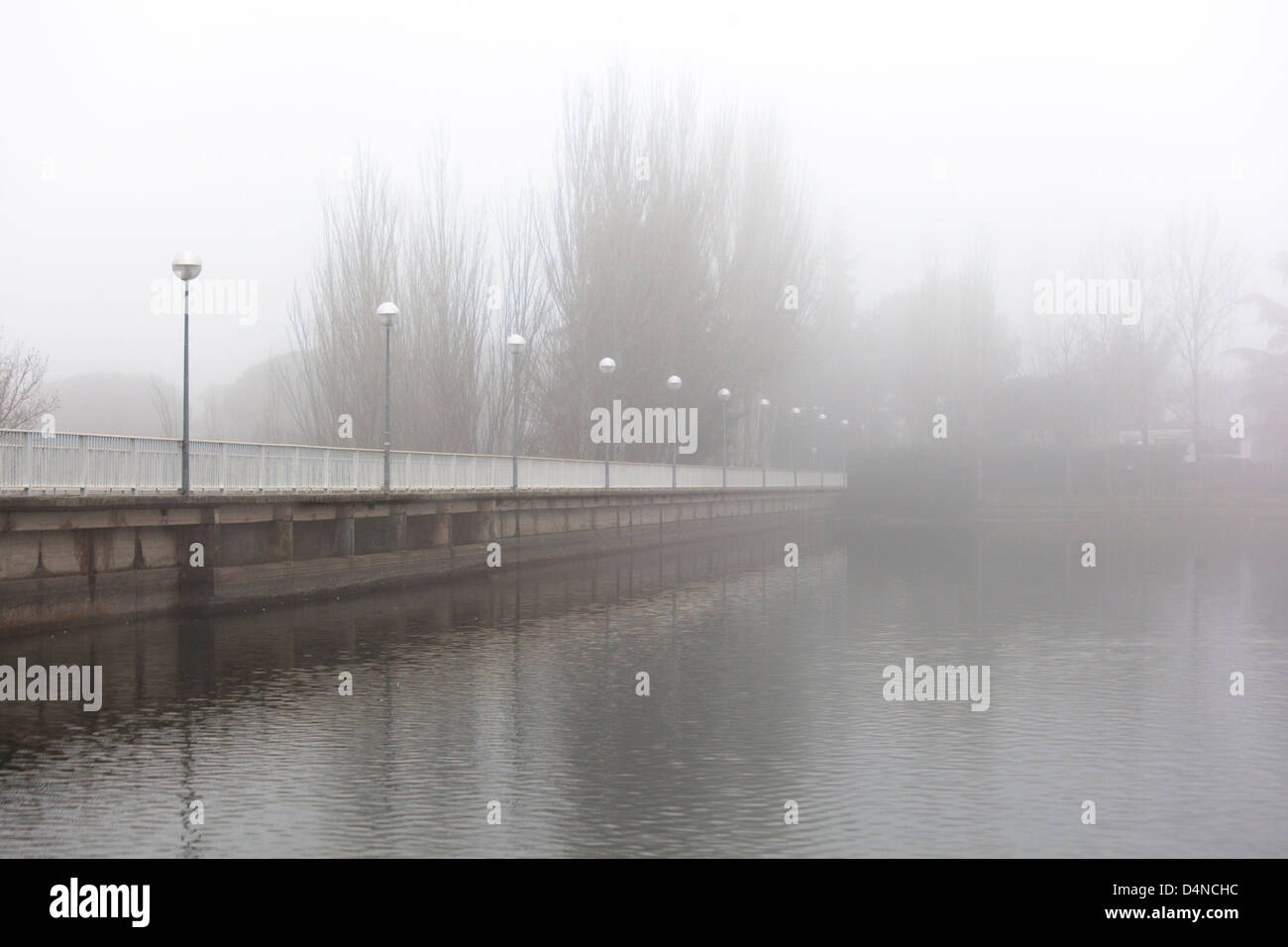 Bridge over lake in a foggy day Stock Photo - Alamy