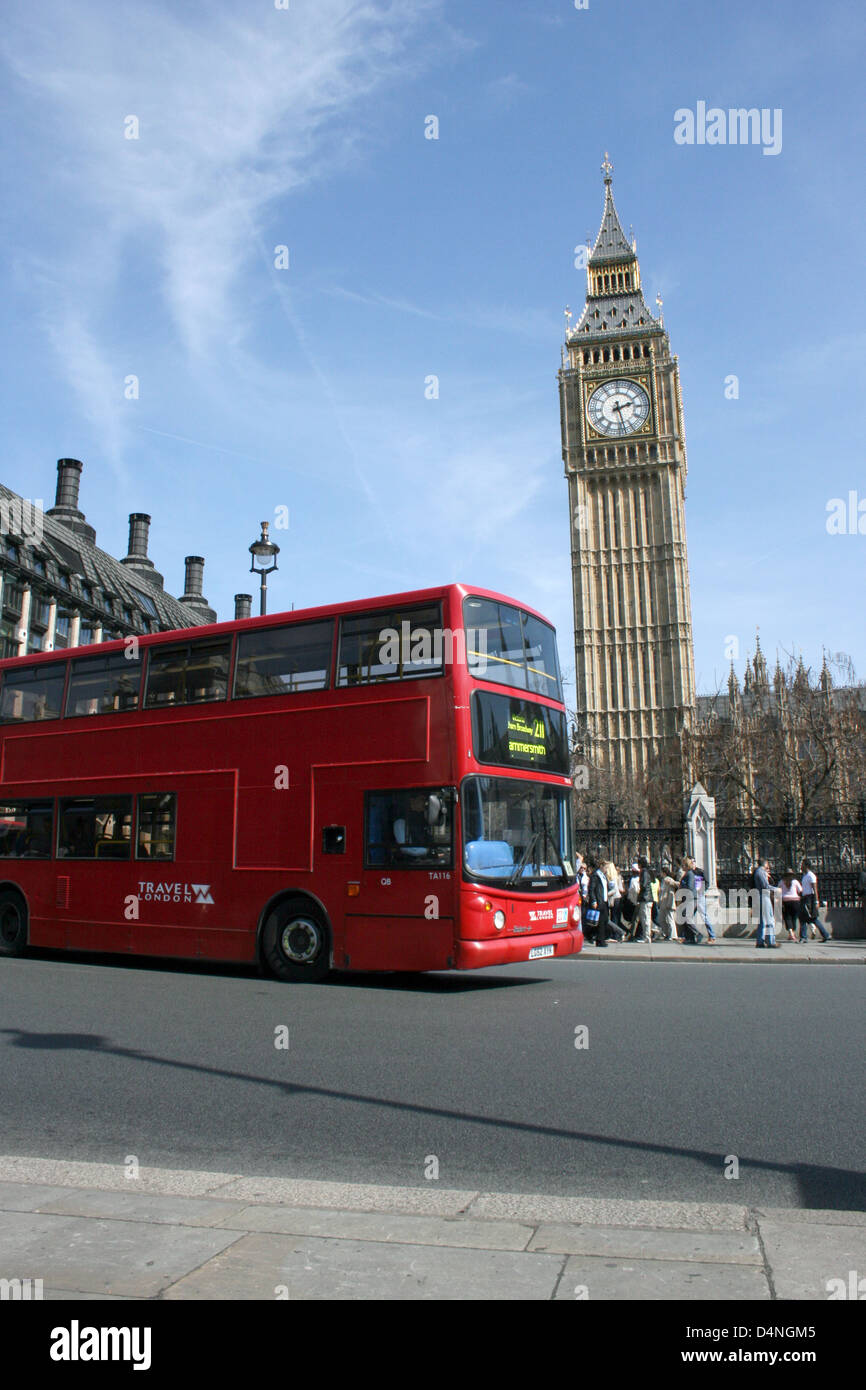 London red bus drives by Big Ben at House of Parliament, London, England Stock Photo
