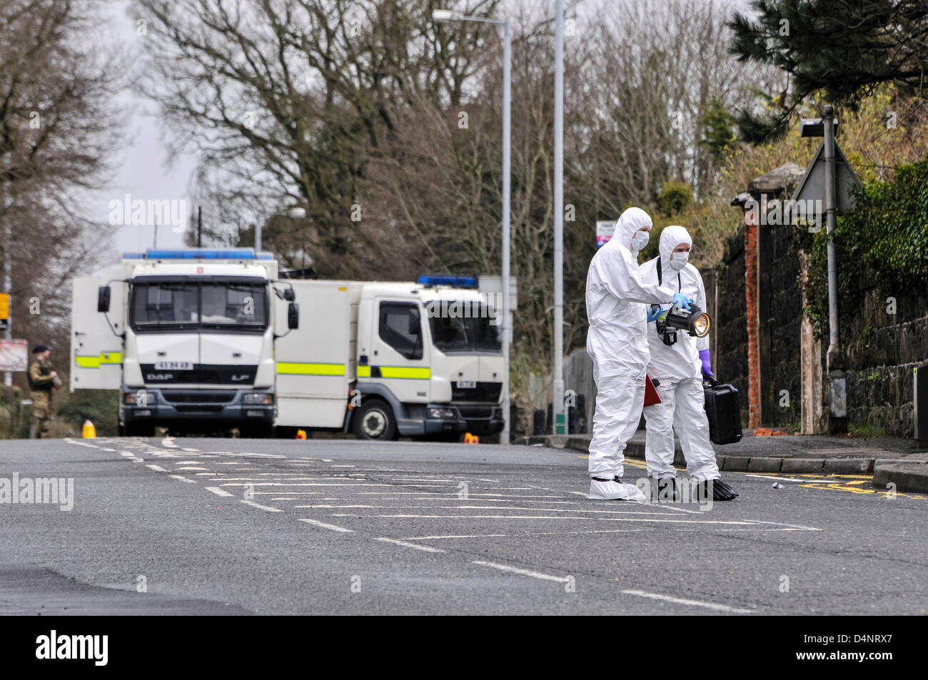 17/03/2013, Newtownabbey, Northern Ireland.  Two officers dressed in forensic suits examine a device found in the grounds of a Roman Catholic chapel shortly before 9am. Stock Photo