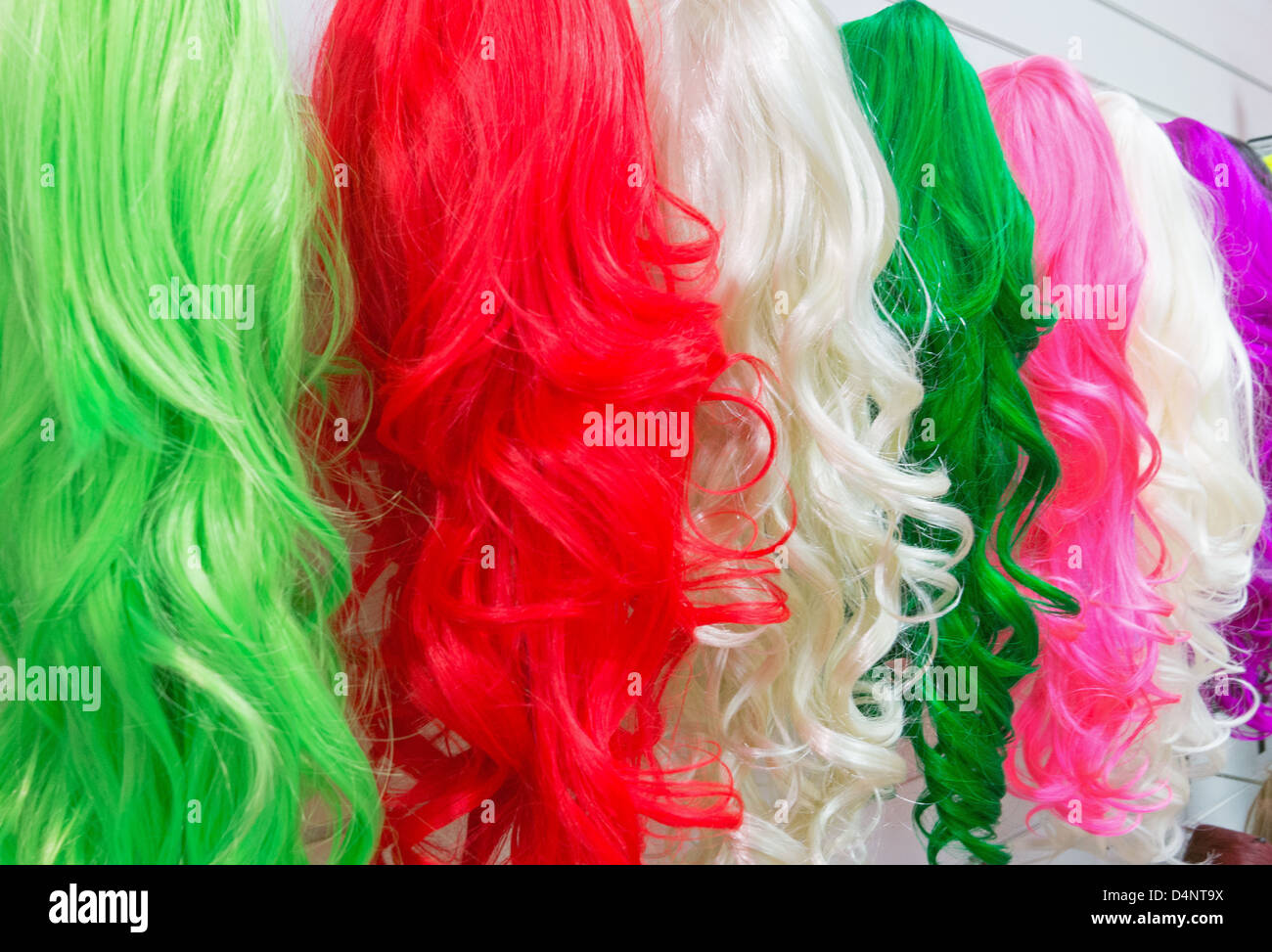 Brightly coloured lady's wigs in a shop within Eldon Square Newcastle north east England UK Stock Photo